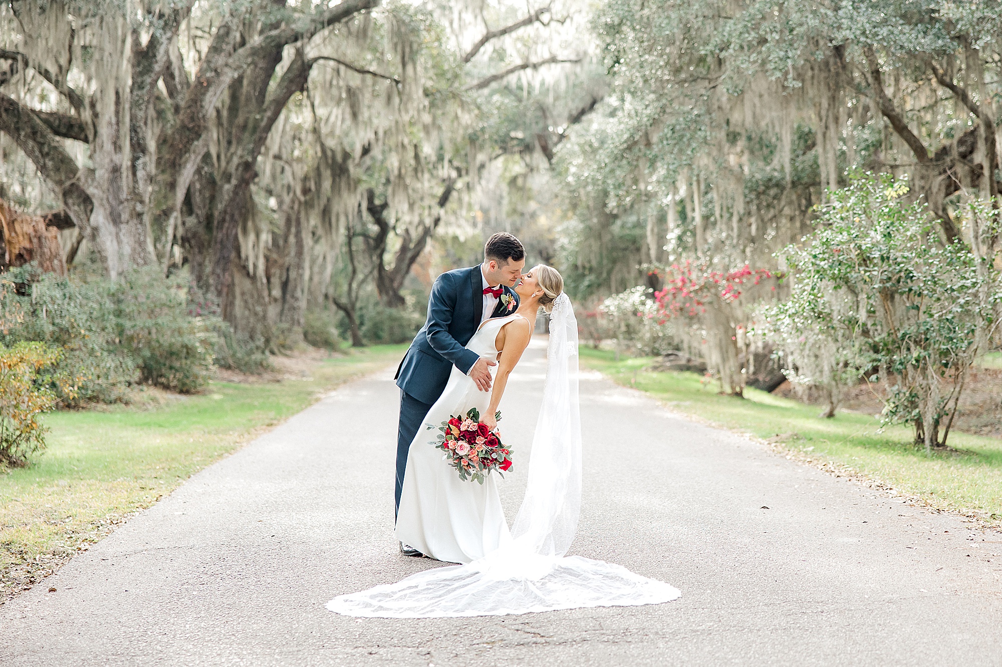 newlyweds kiss under canopy of trees in Charleston SC