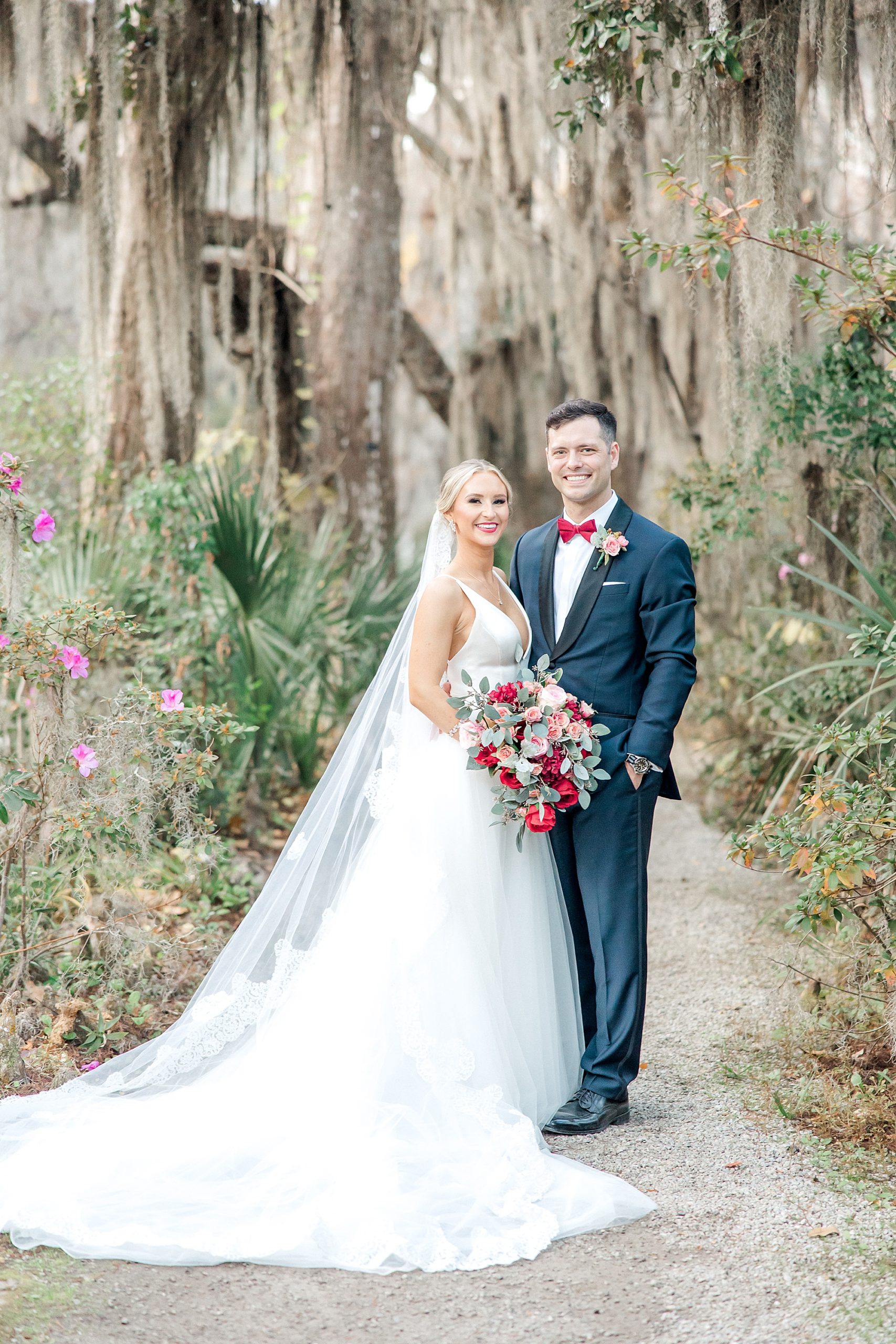 newlyweds stand under beautiful trees in the garden of Magnolia Plantation and Gardens