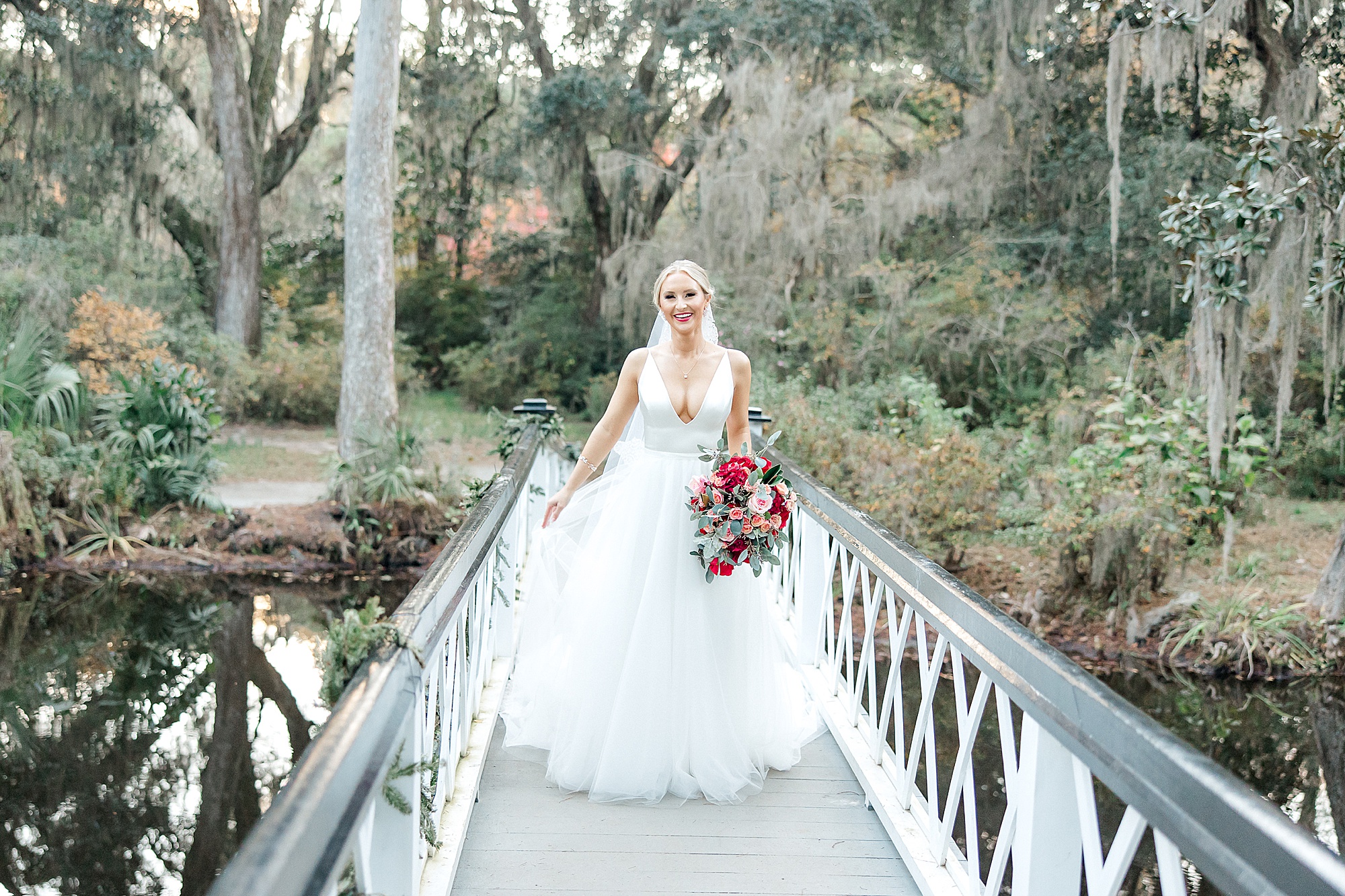 bride walks across white bridge at Magnolia Plantation and Gardens