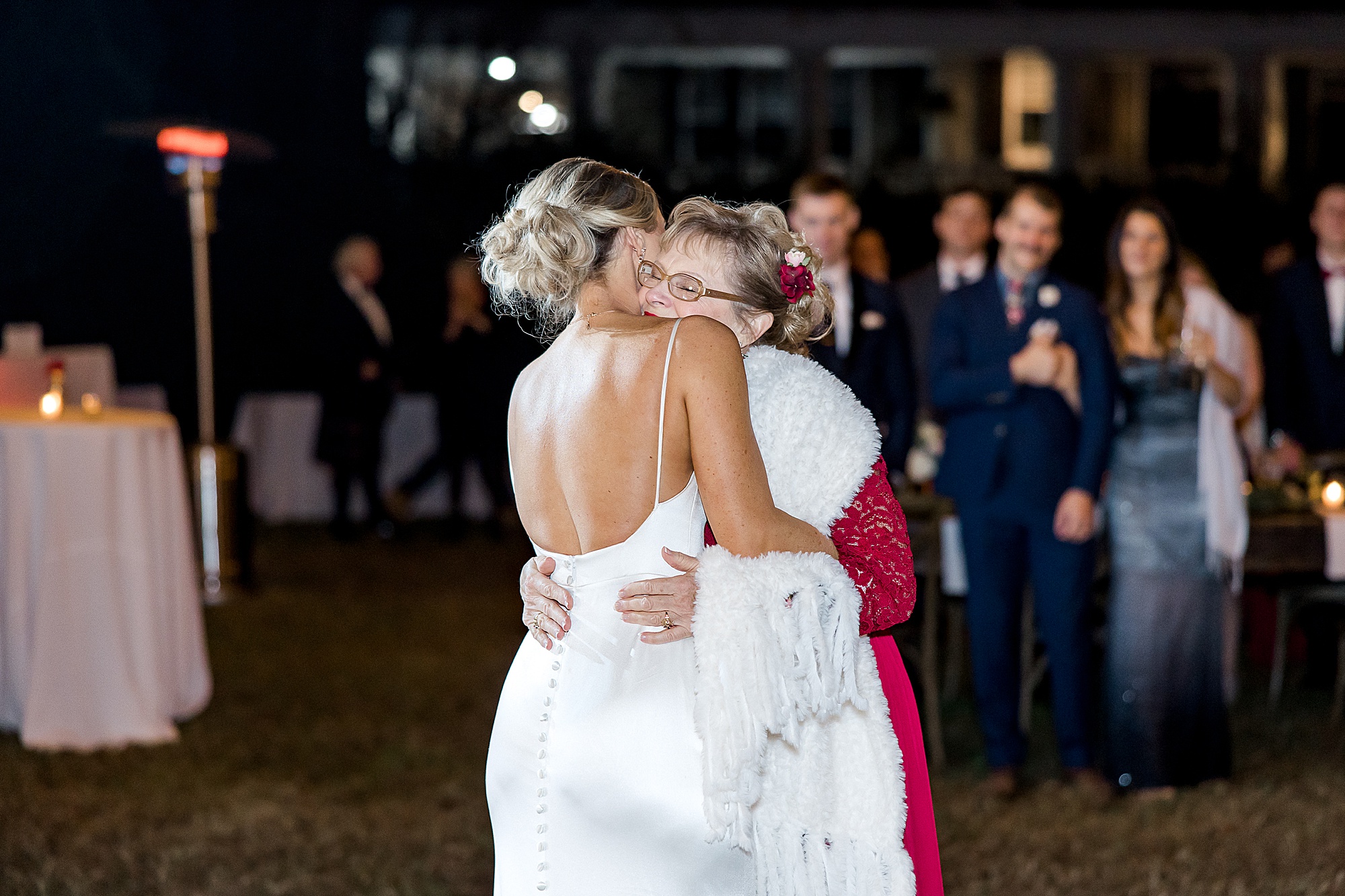 bride hugs her mom at wedding reception