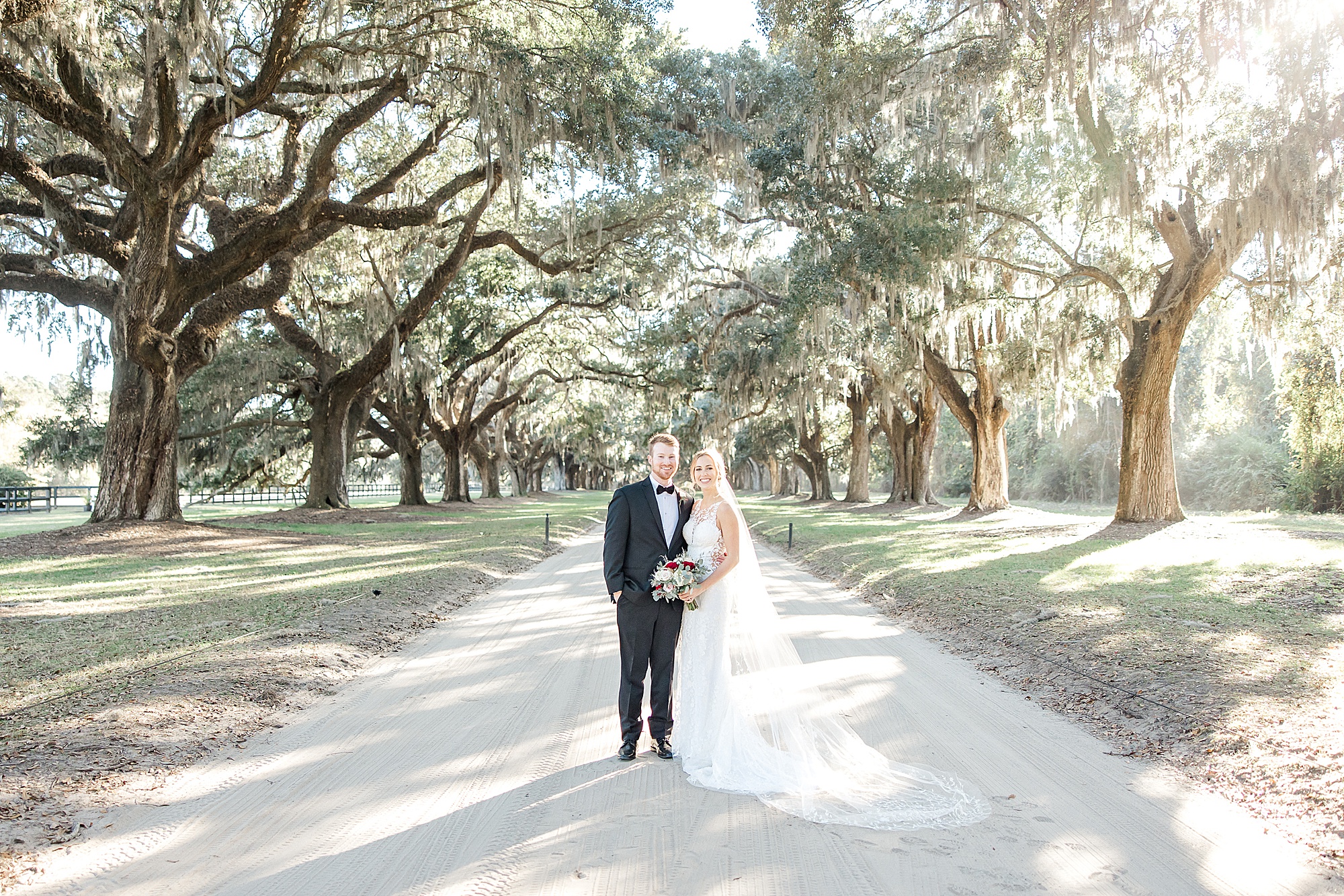 Couple stand under famous Oak avenue in Charleston SC