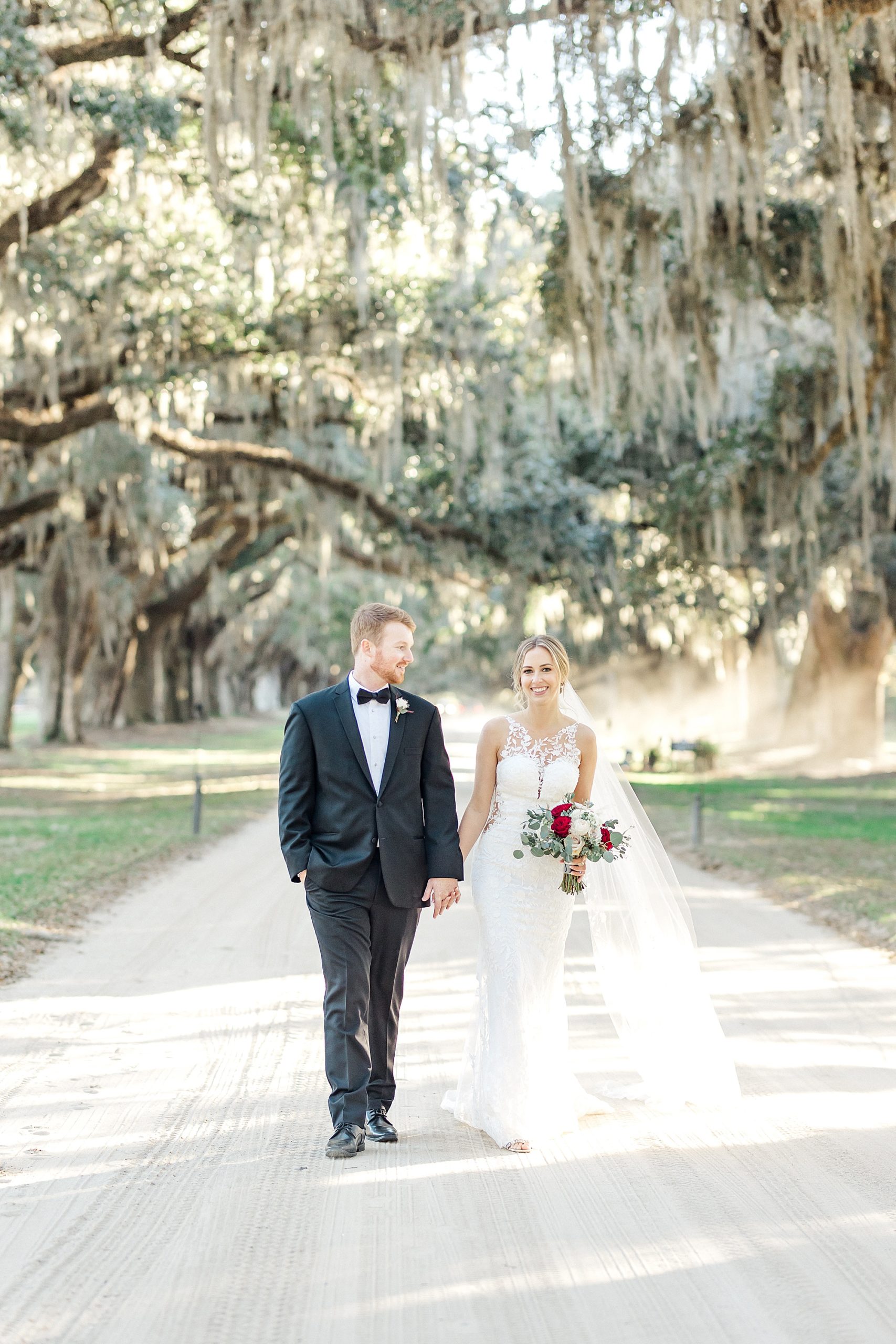 spanish moss covered trees frame the bride and groom