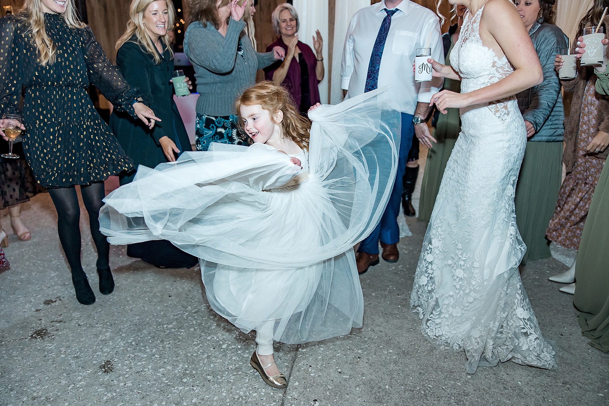 flower girl twirls her dress on dance floor