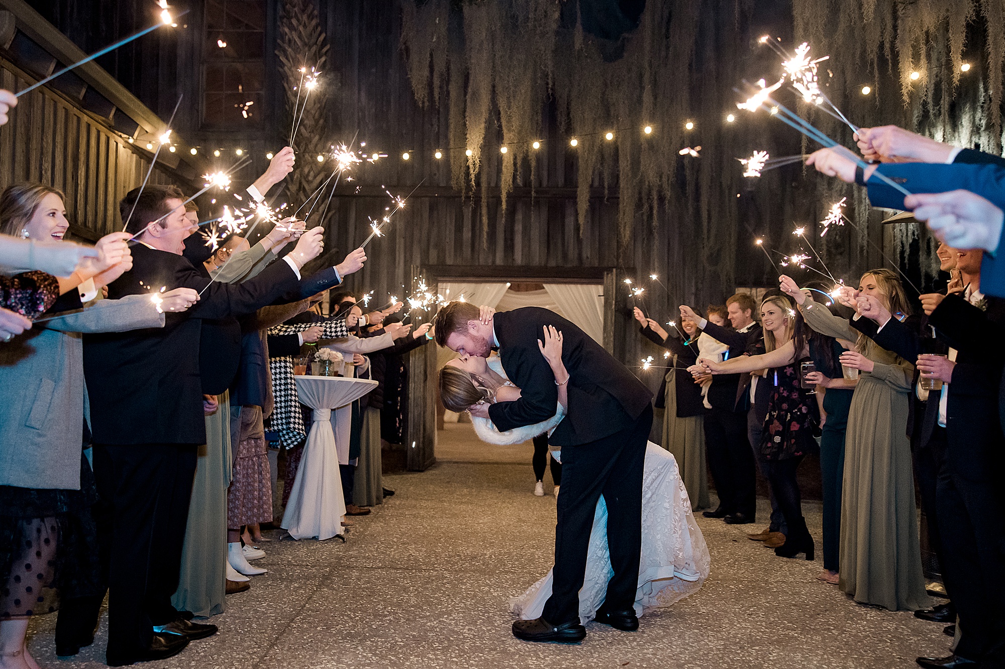 wedding guests light sparklers and send off the newlyweds
