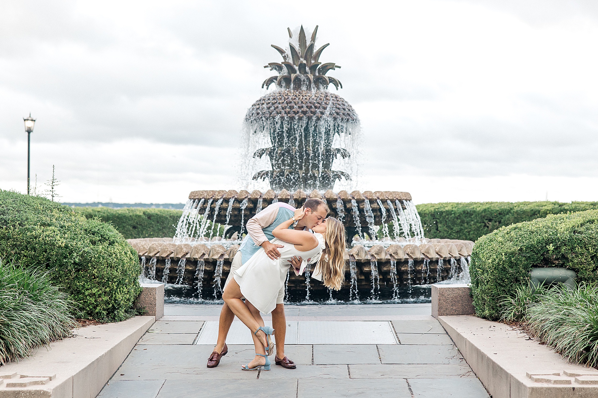 man dips his fiance in front of the pineapple fountain in Charleston SC