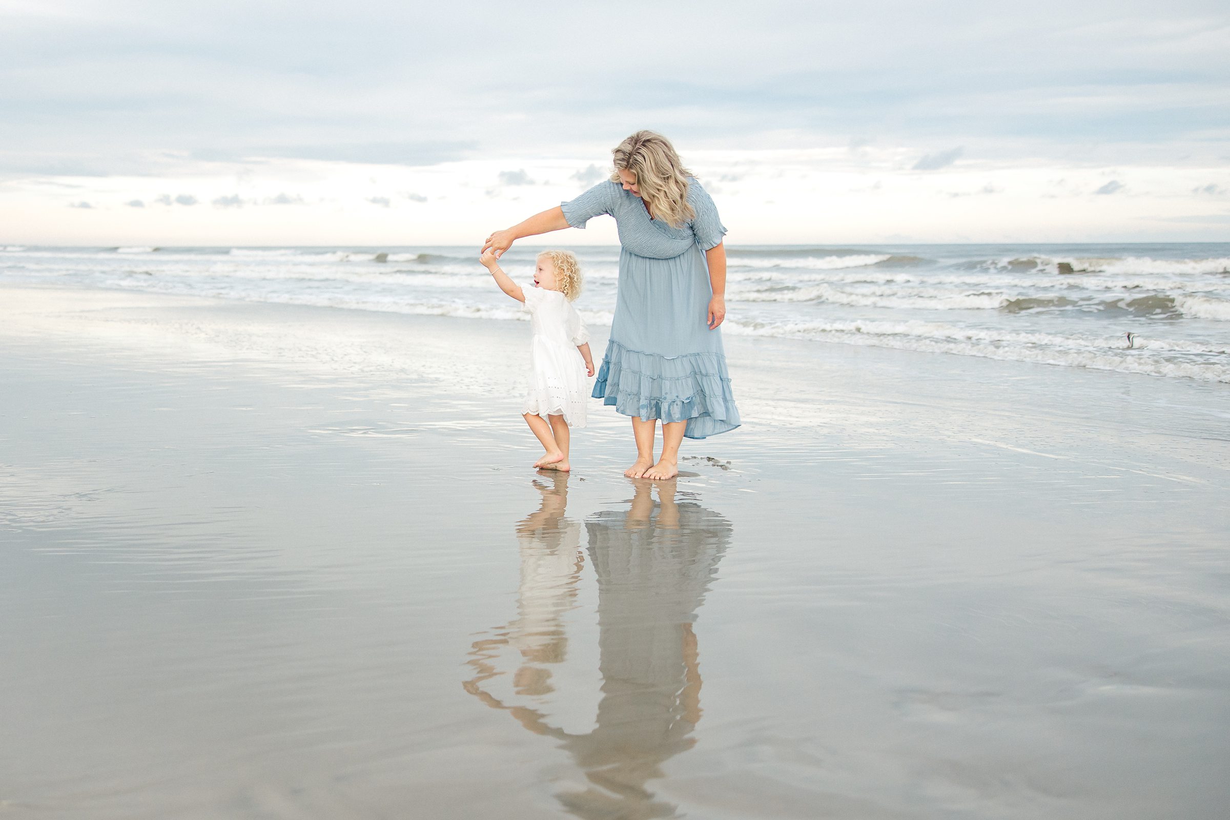 Mother and daughter dance on Charleston beach