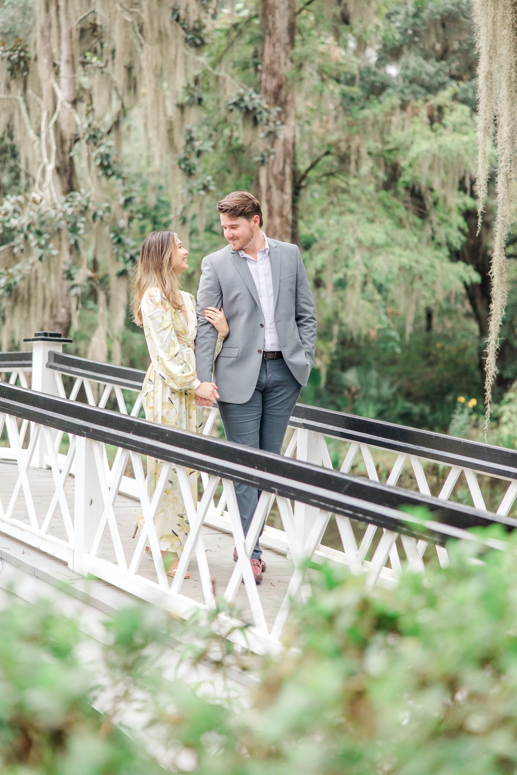 Couple walks on white bridge at Magnolia Plantation and Gardens