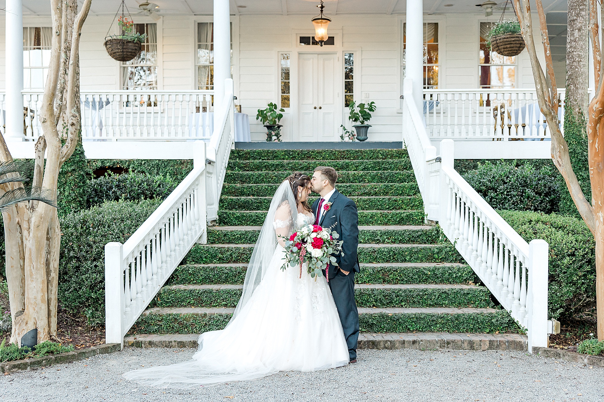 newlyweds in front of the ivy covered stairs of the Old Wide Awake Plantation