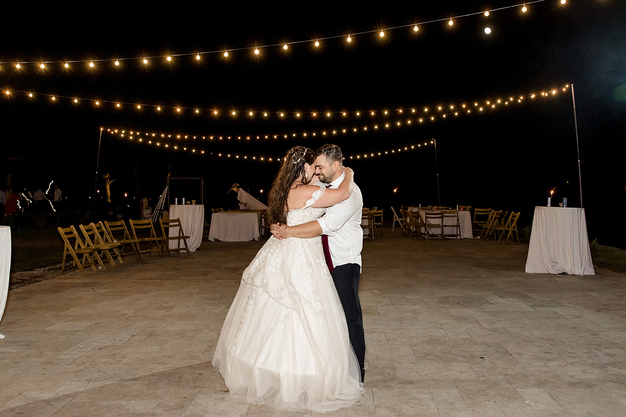 newlyweds dance together after wedding guests leave
