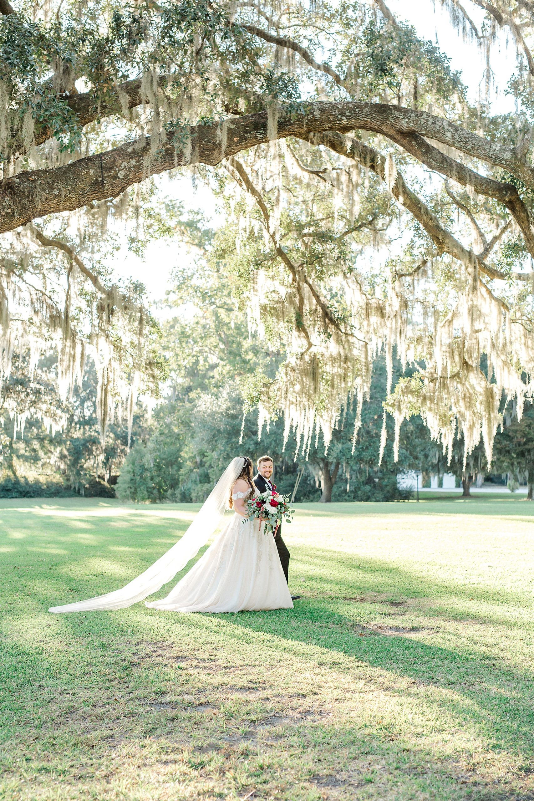 couple under old oak trees covered in Spanish moss at the Old Wide Awake Plantation
