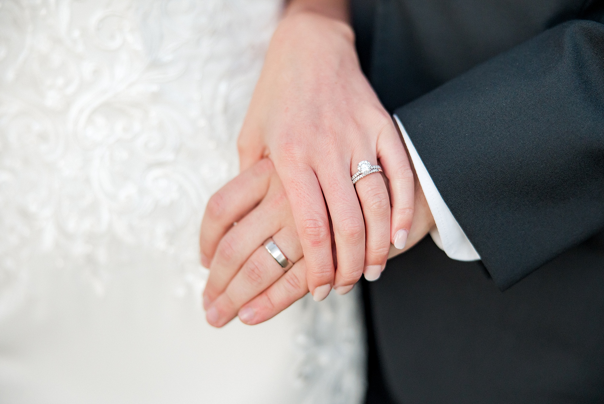 newlyweds hold hands showing off wedding rings