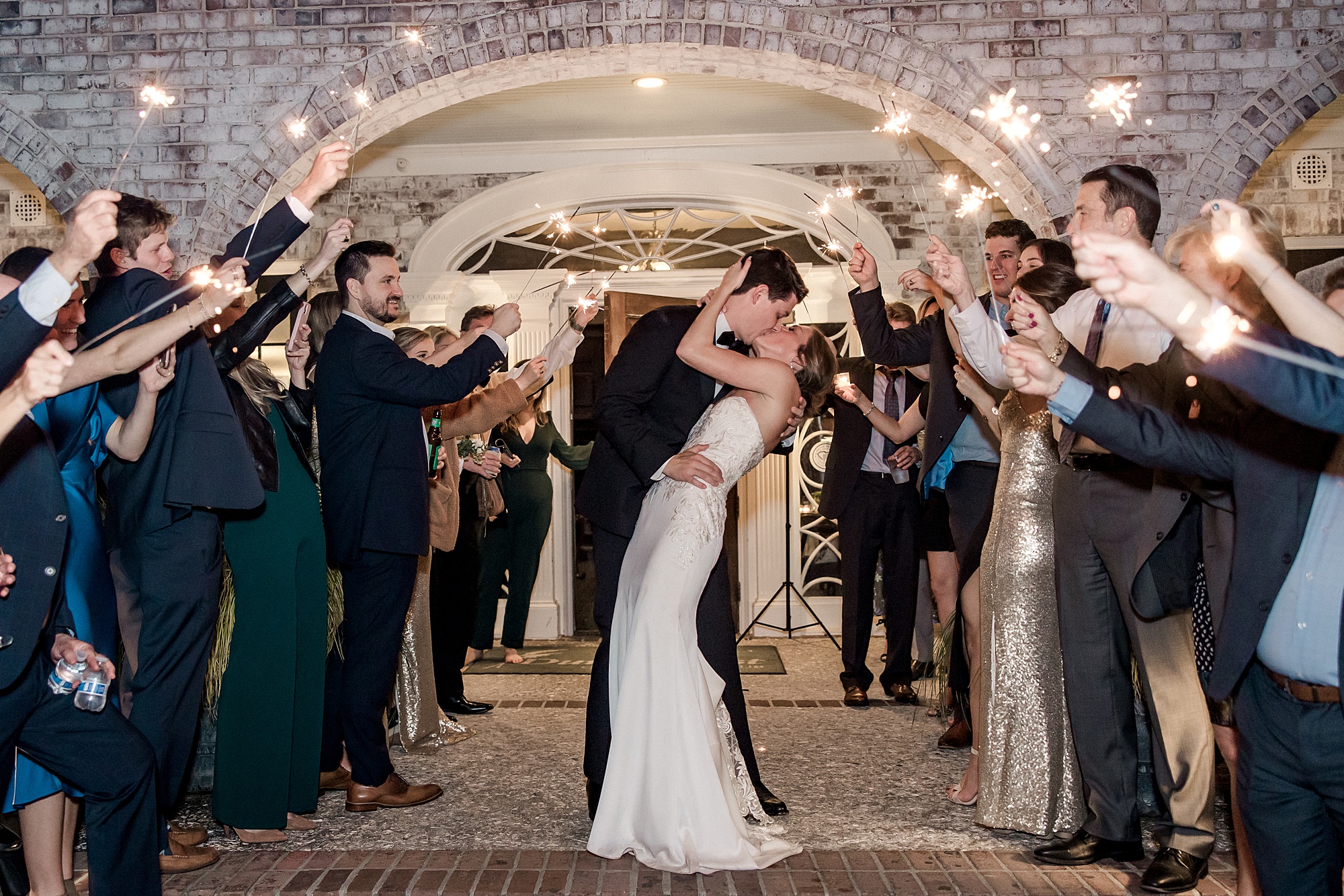 wedding guests celebrate newlyweds with sparklers as they exit