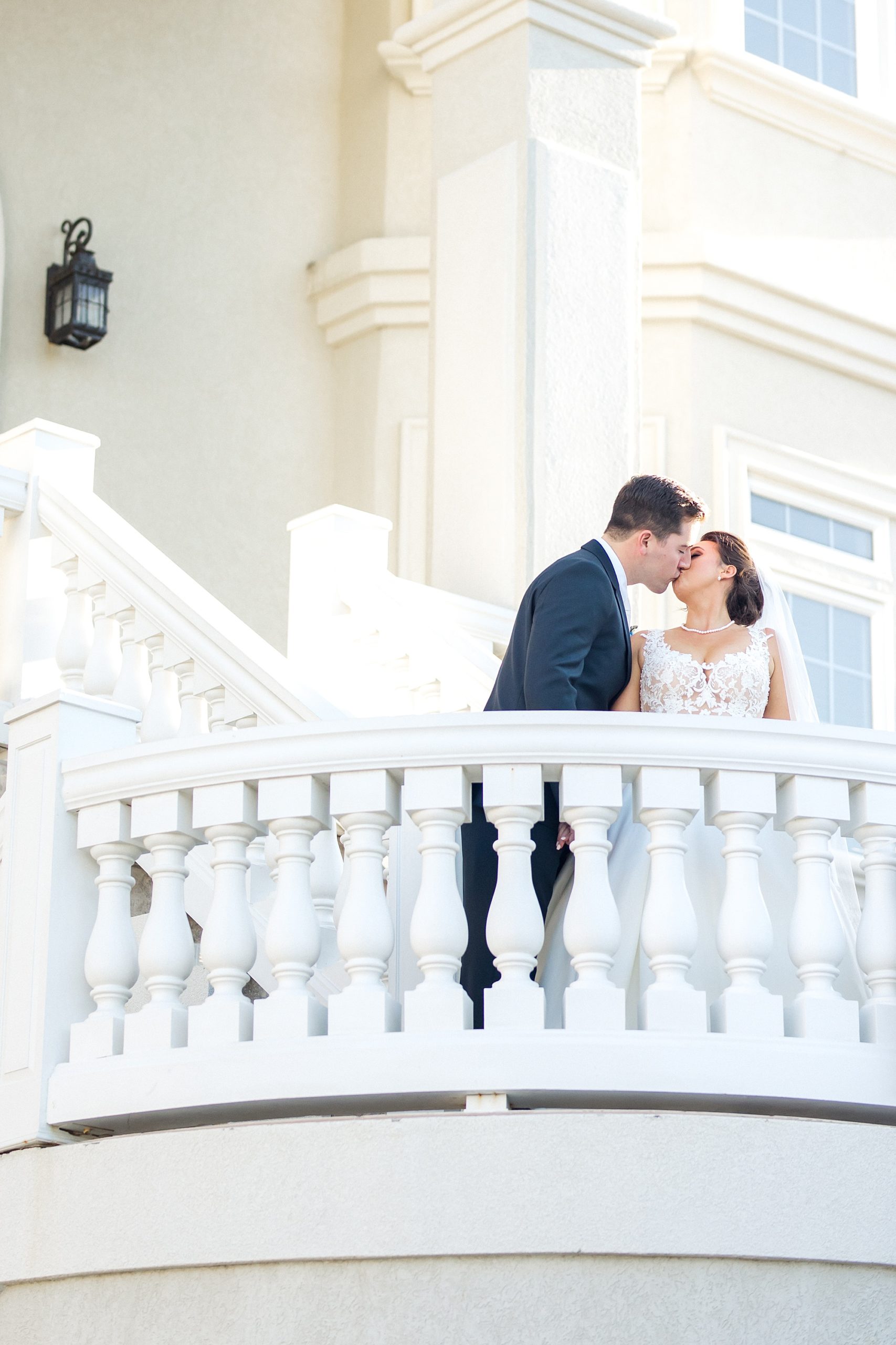 husband and wife kiss on balcony