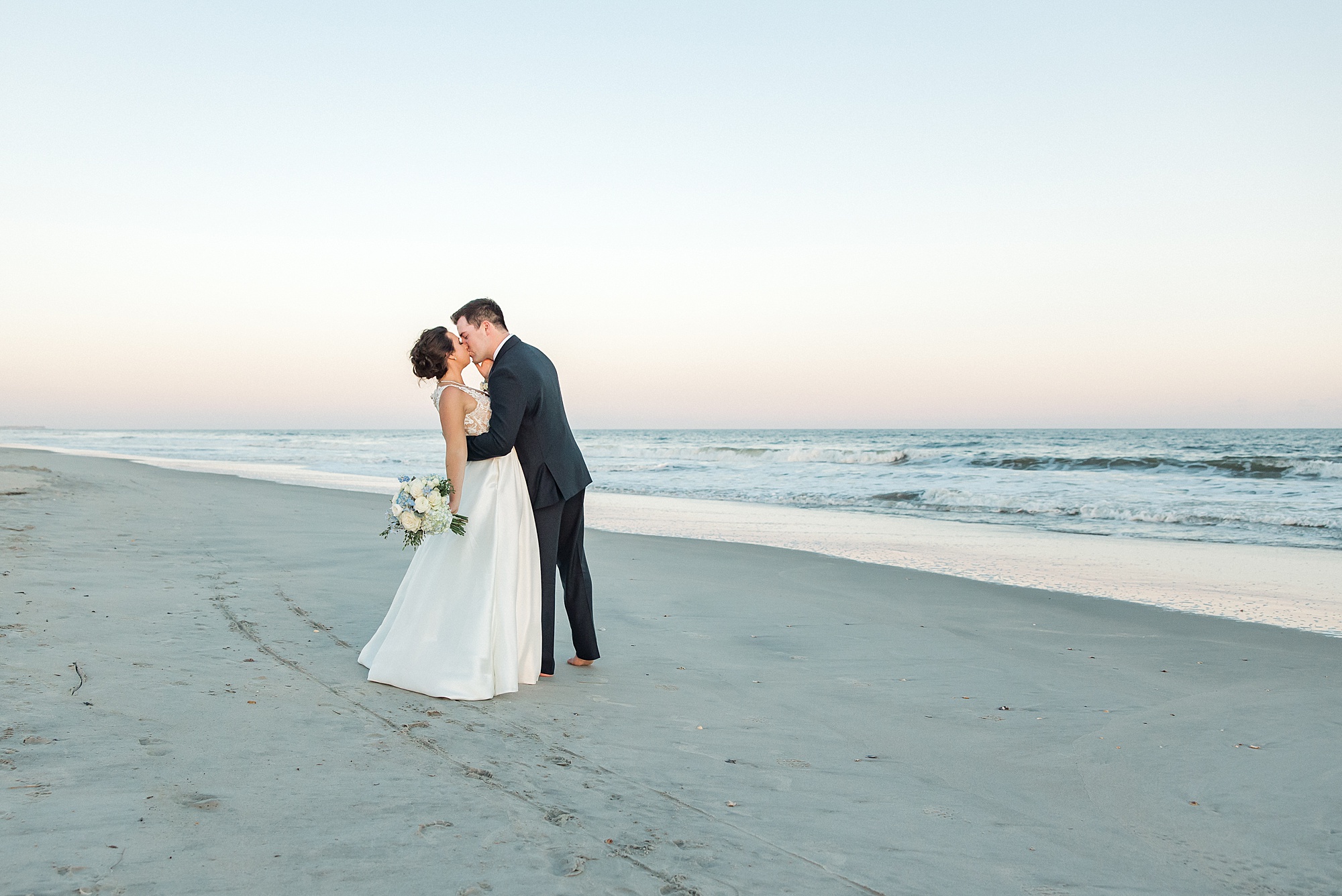 newlyweds on beach for wedding portraits