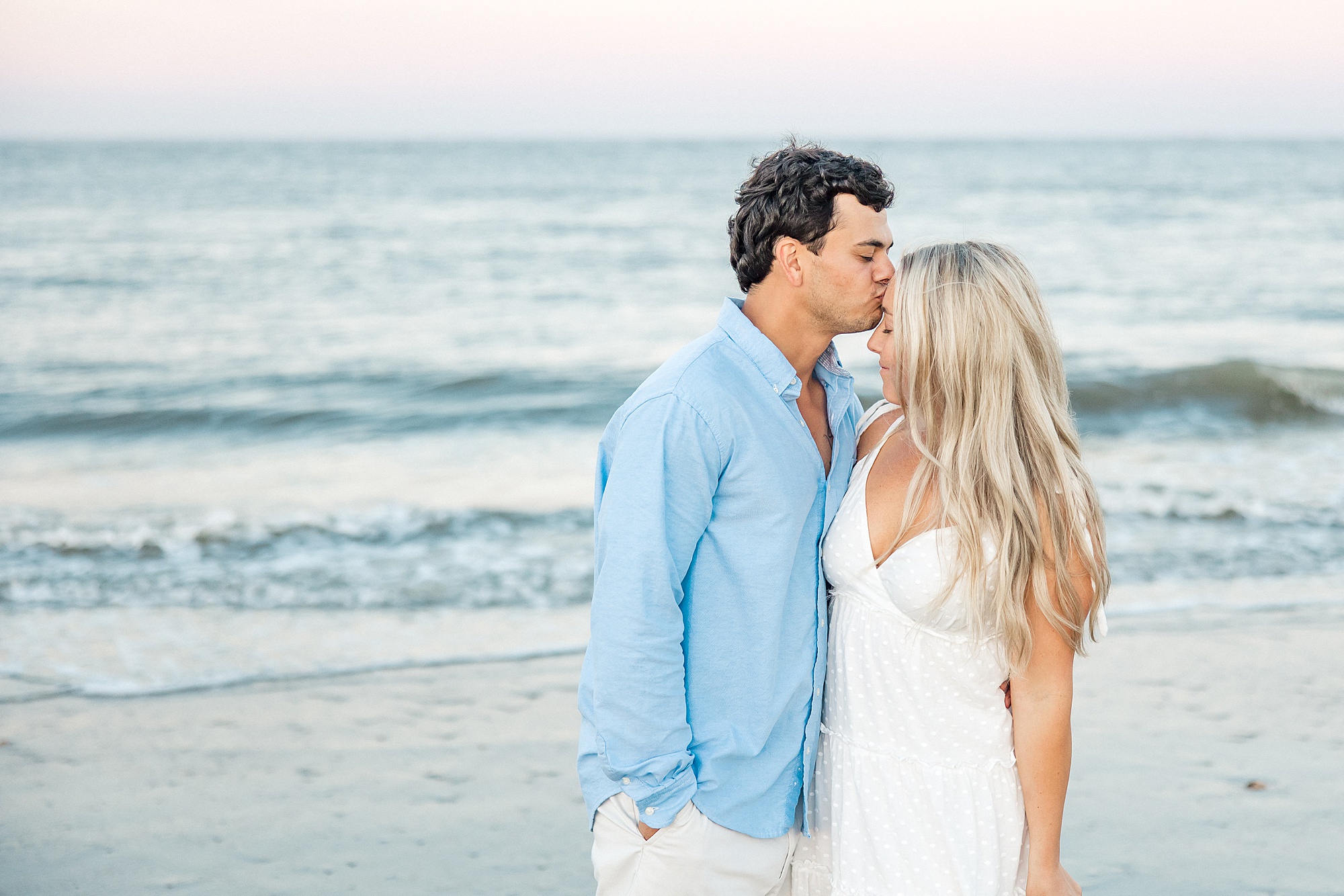 man kisses fiance's head during Folly Beach Engagement Session