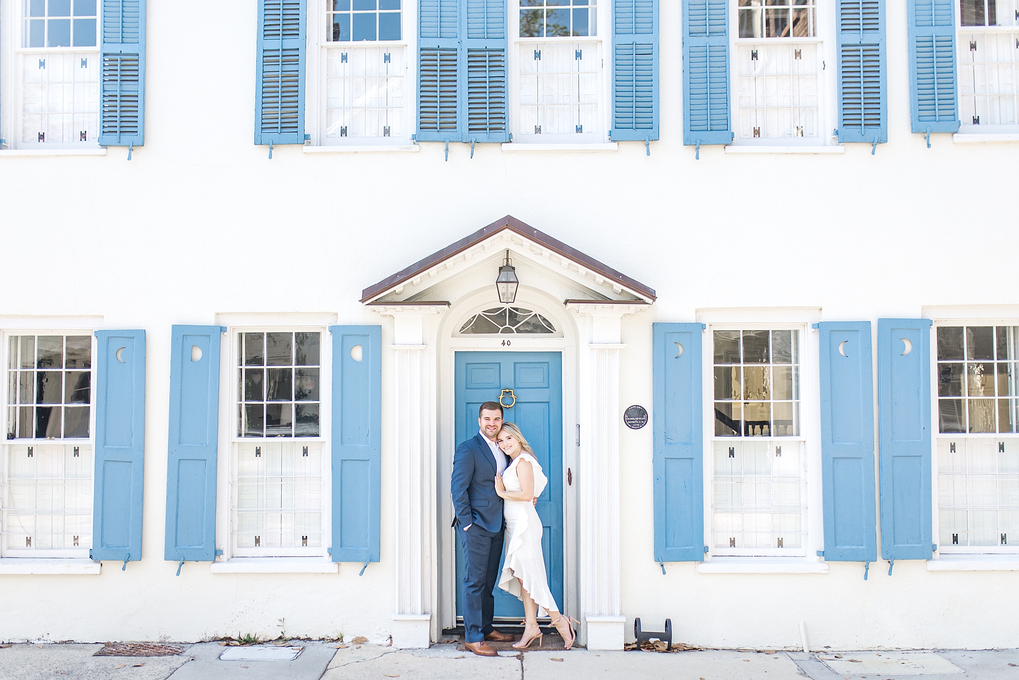 Historic Downtown Charleston SC Engagement in front of white house with blue shutters
