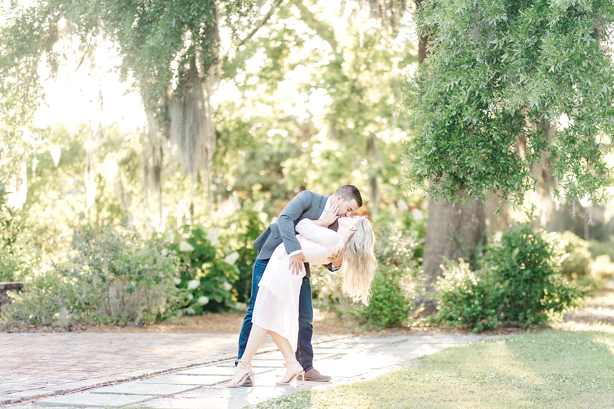 man kisses his soon-to-be bride during Downtown Charleston SC Engagement portraits