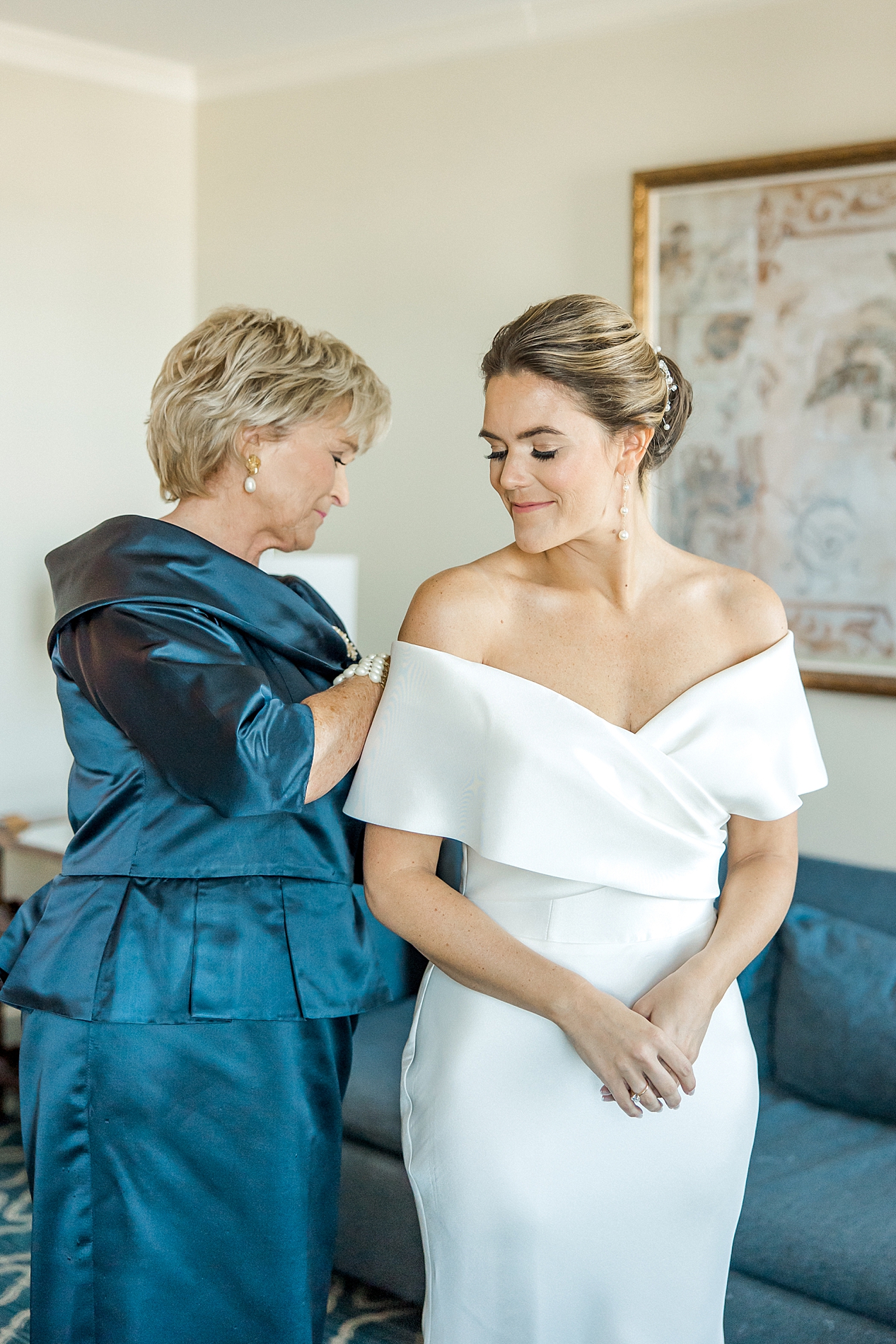 mom helping daughter get ready for wedding day