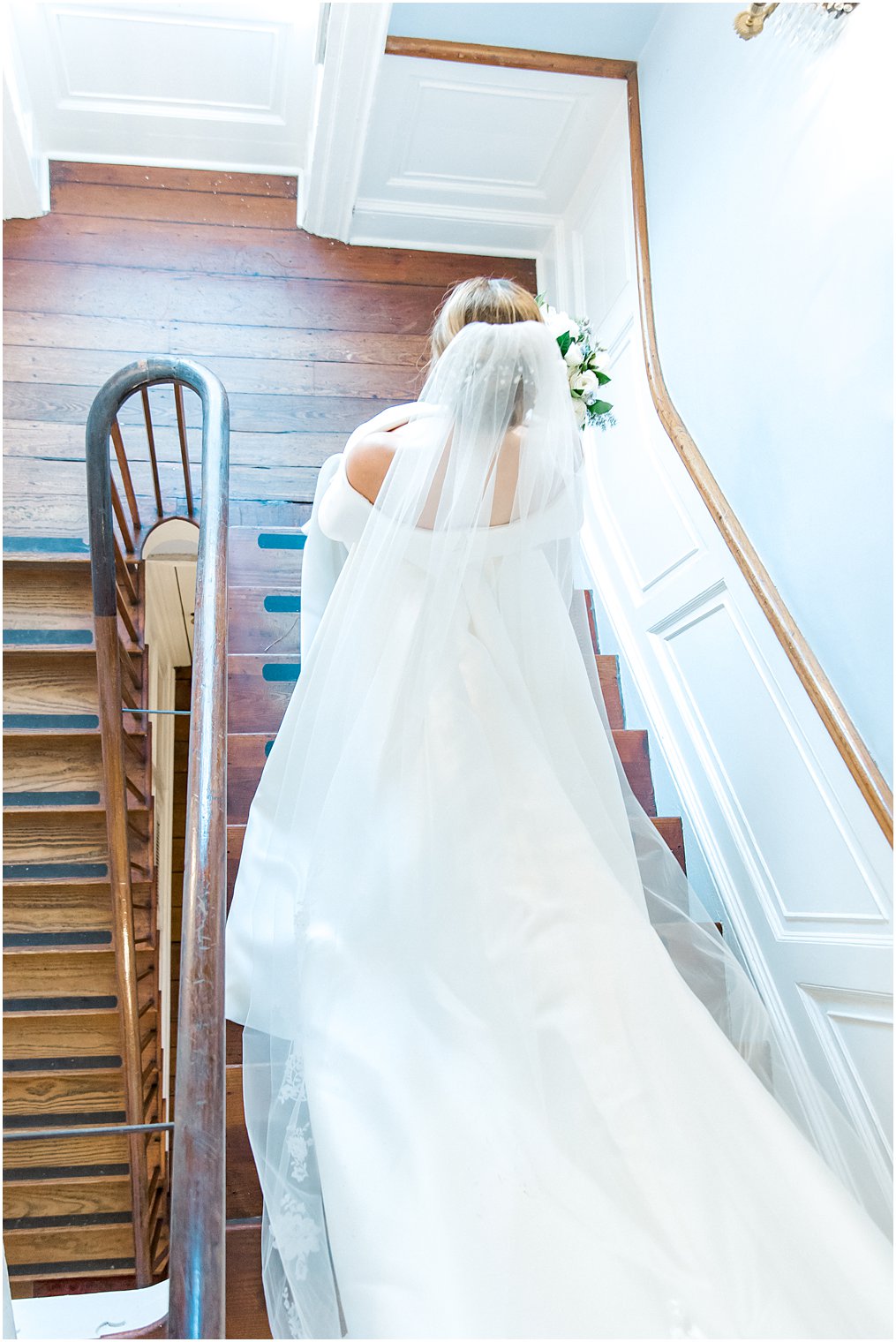 Back of bride's wedding dress as she walks down the stairs