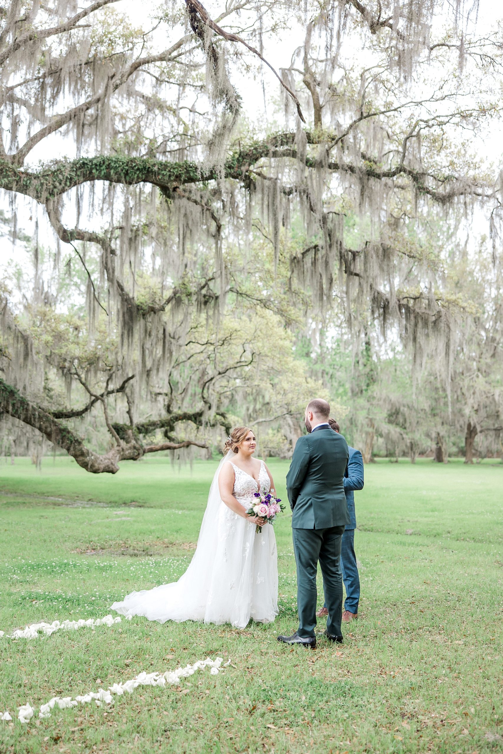 couple have wedding ceremony under spanish moss covered oak trees