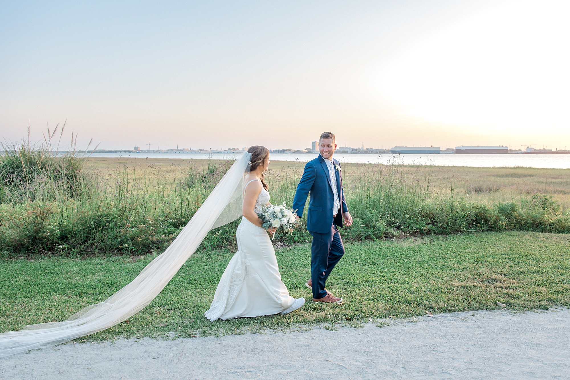newlyweds walk together after ceremony at sunset