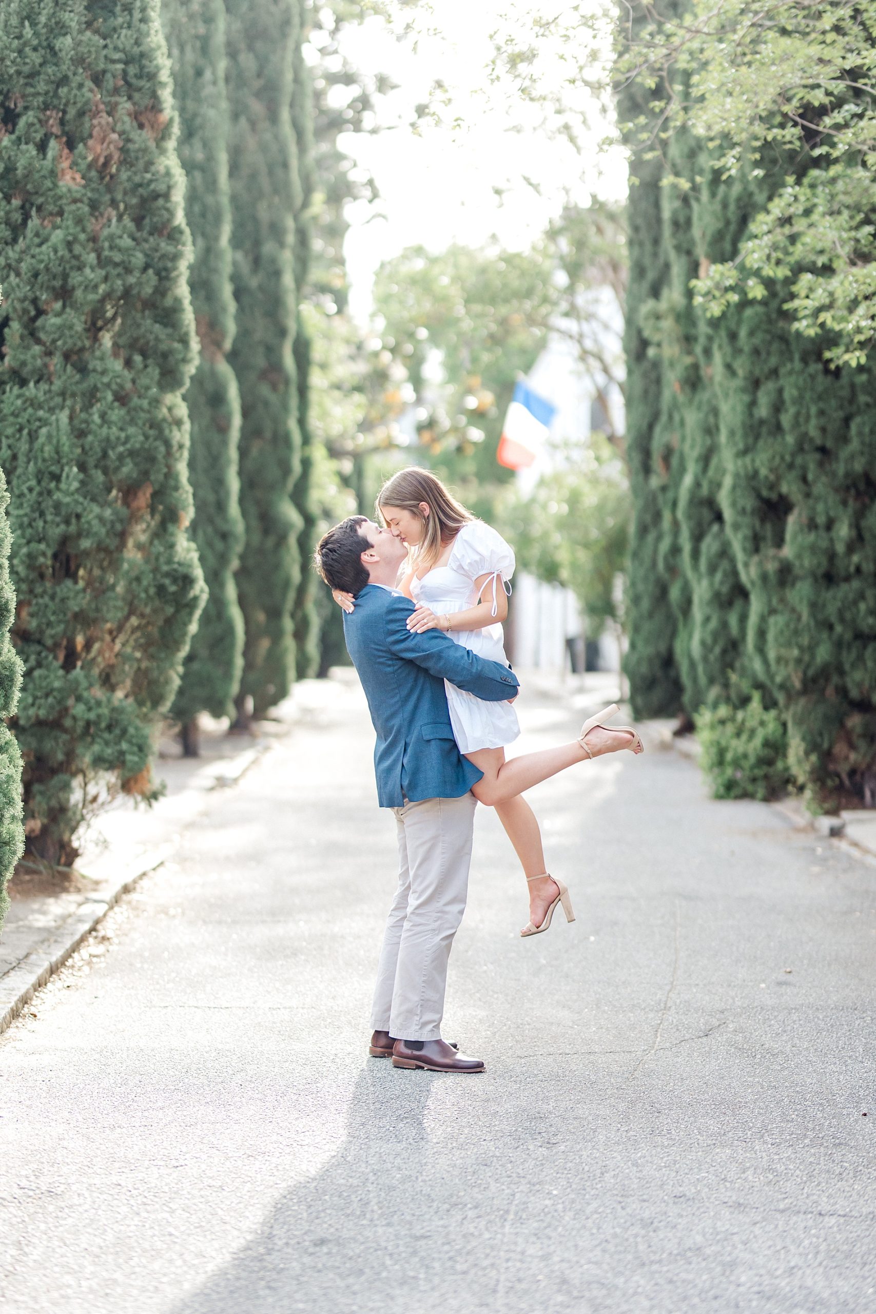 man lifts his fiance up during Historic Downtown Charleston Spring Engagement