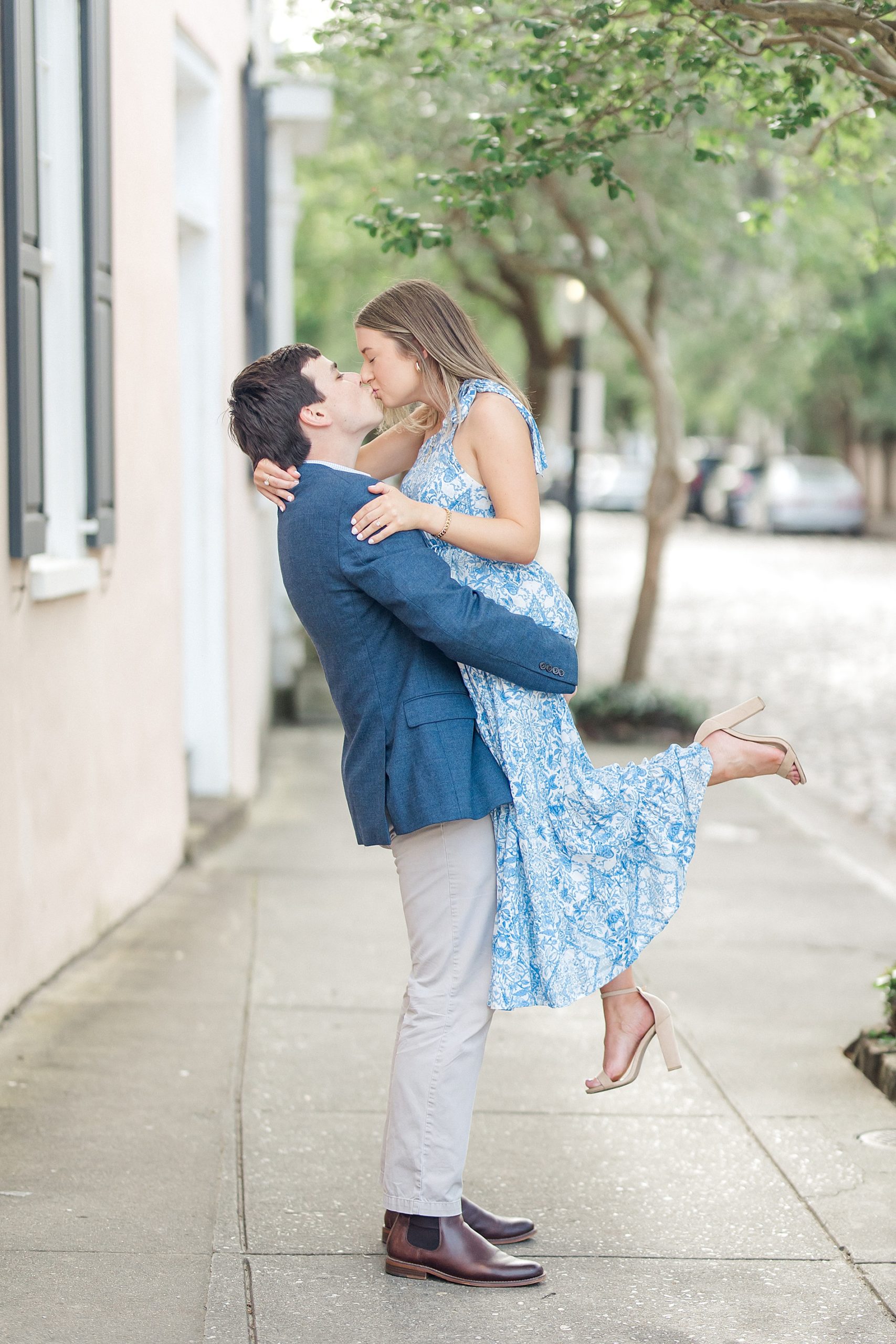 man lifts his fiance up on the sidewalk in SC