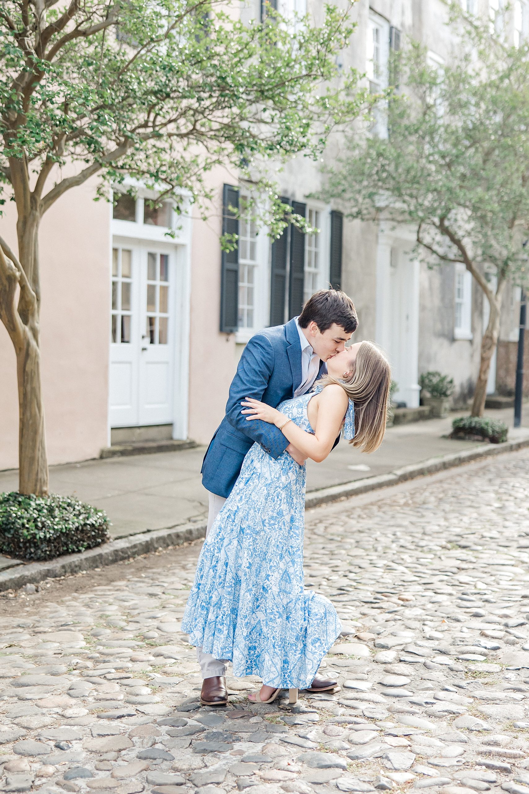 couple kiss in the middle of cobblestone street in downtown Charleston
