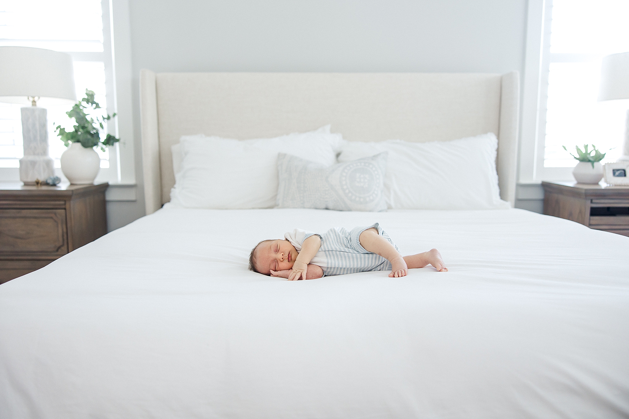 baby boy sleeps on bed during In-Home Newborn + Family Session