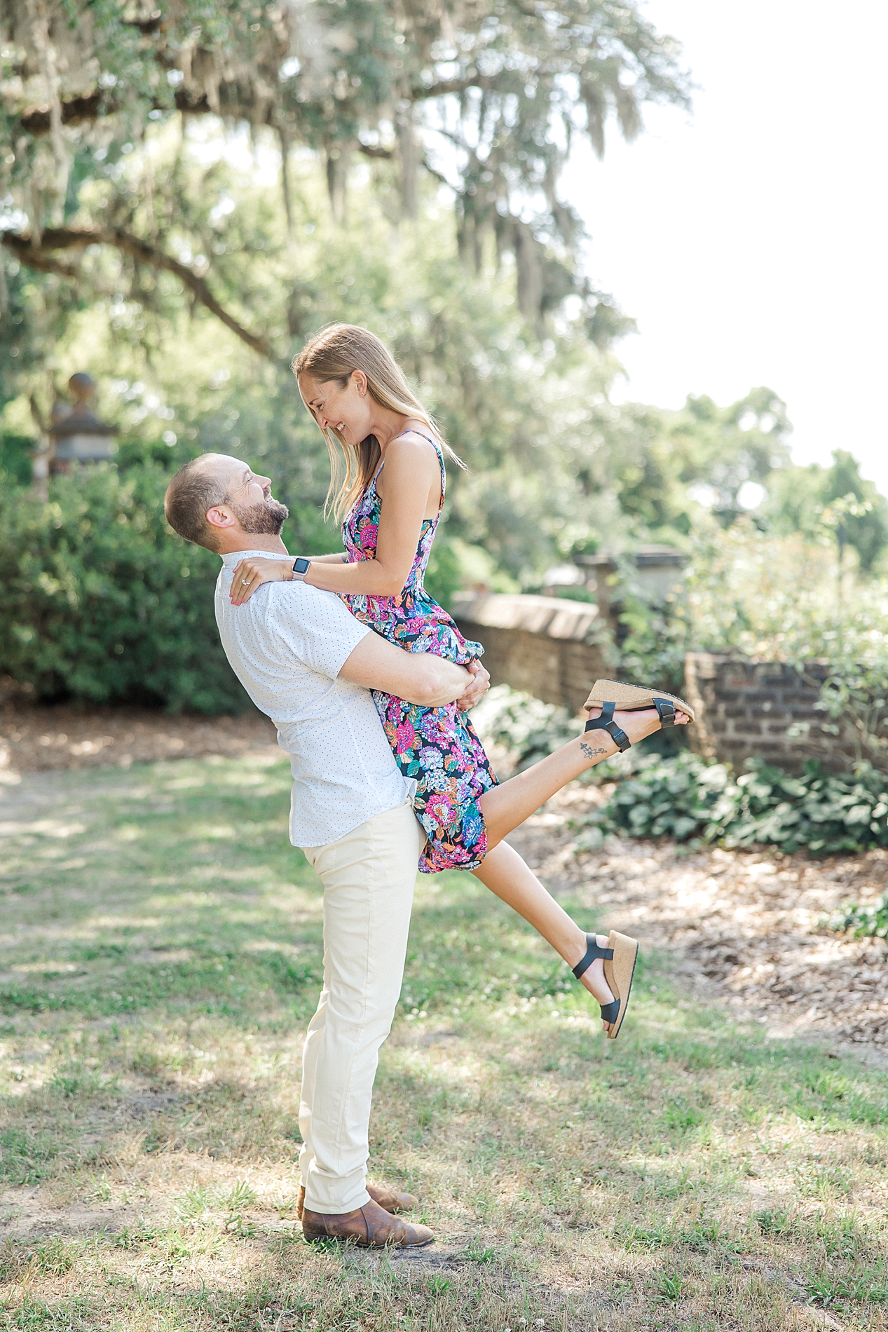 man lifts fiance up in SC during engagement session