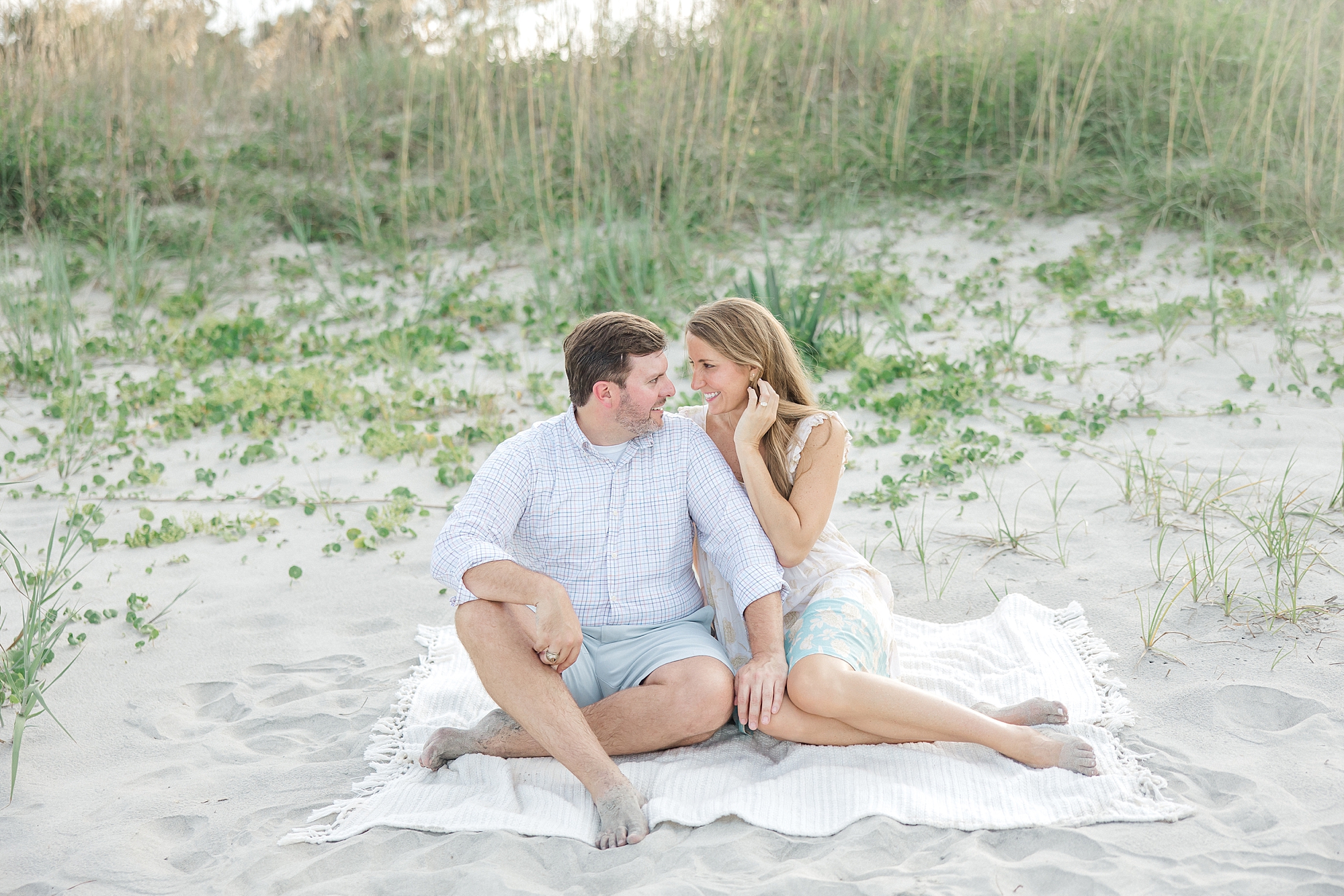 couple sits on blanket at Folly Beach