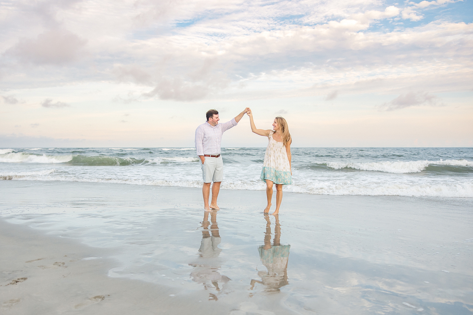 couple stand in the ocean at Folly Beach, SC