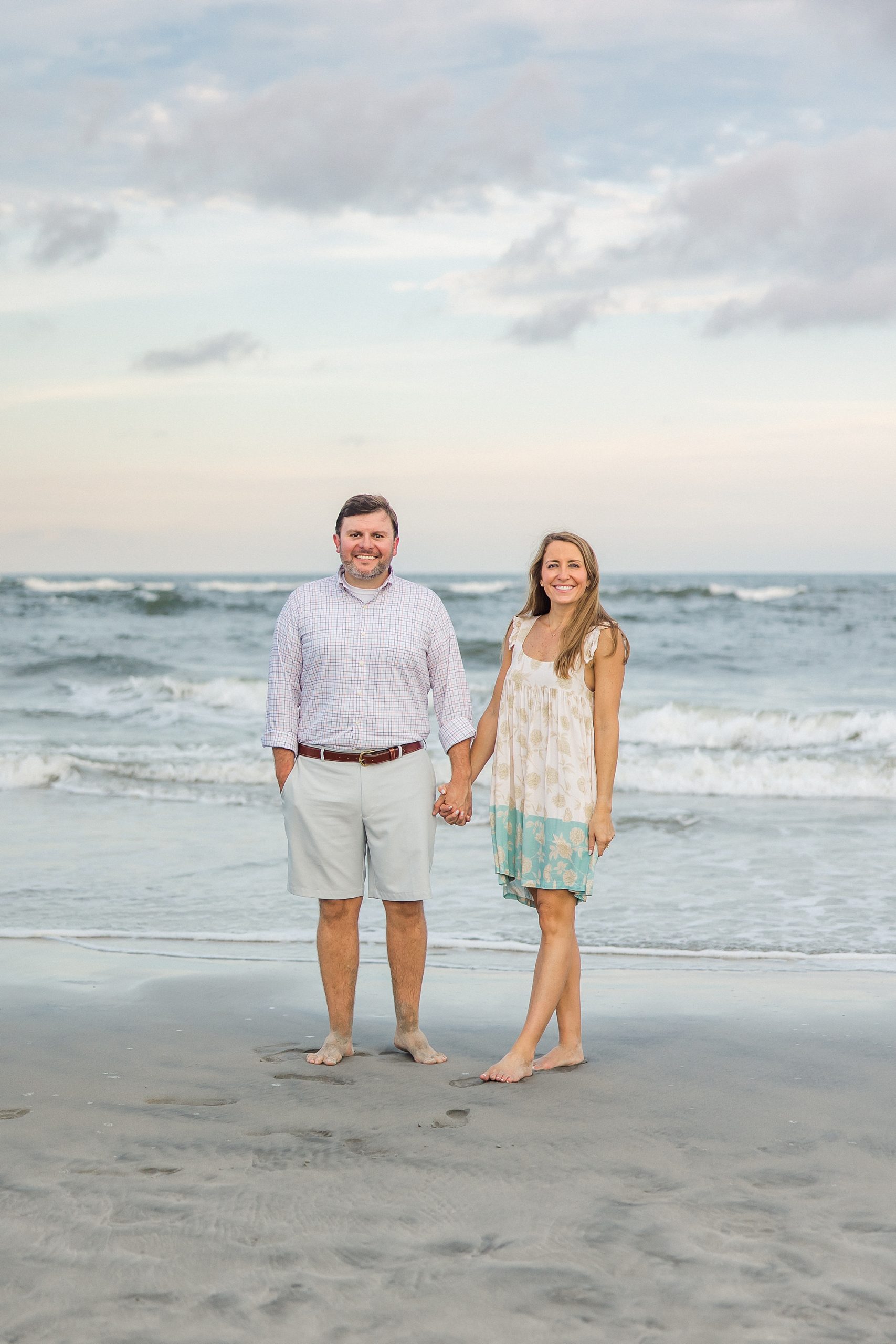 engaged couple hold hands on the beach in SC