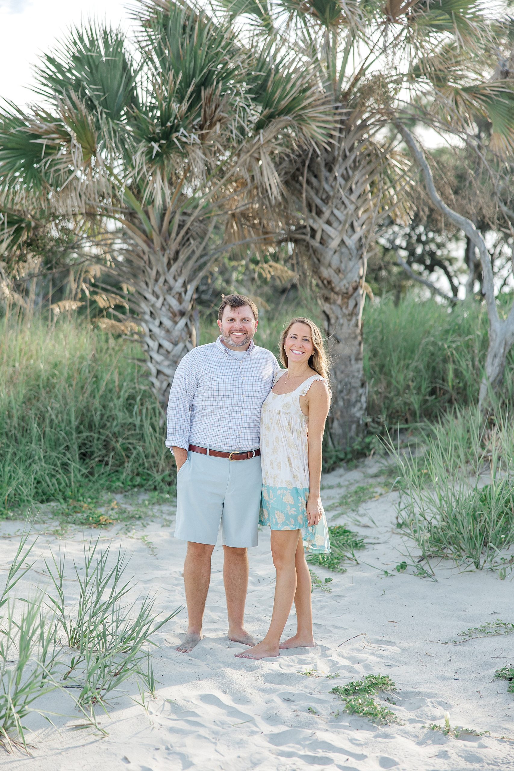 couple stand in front of palm trees on SC beach