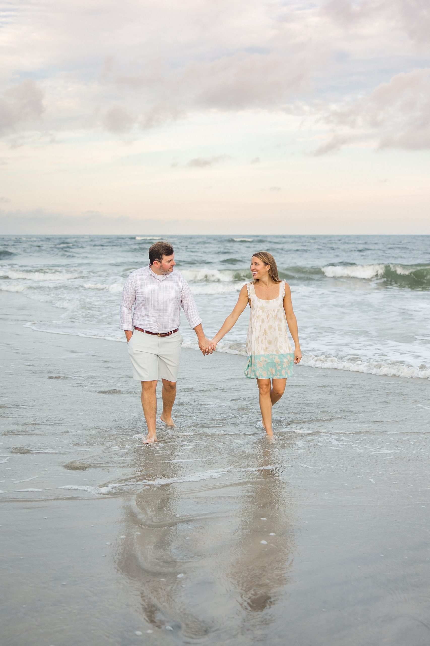 couple walk hand in hand on beach