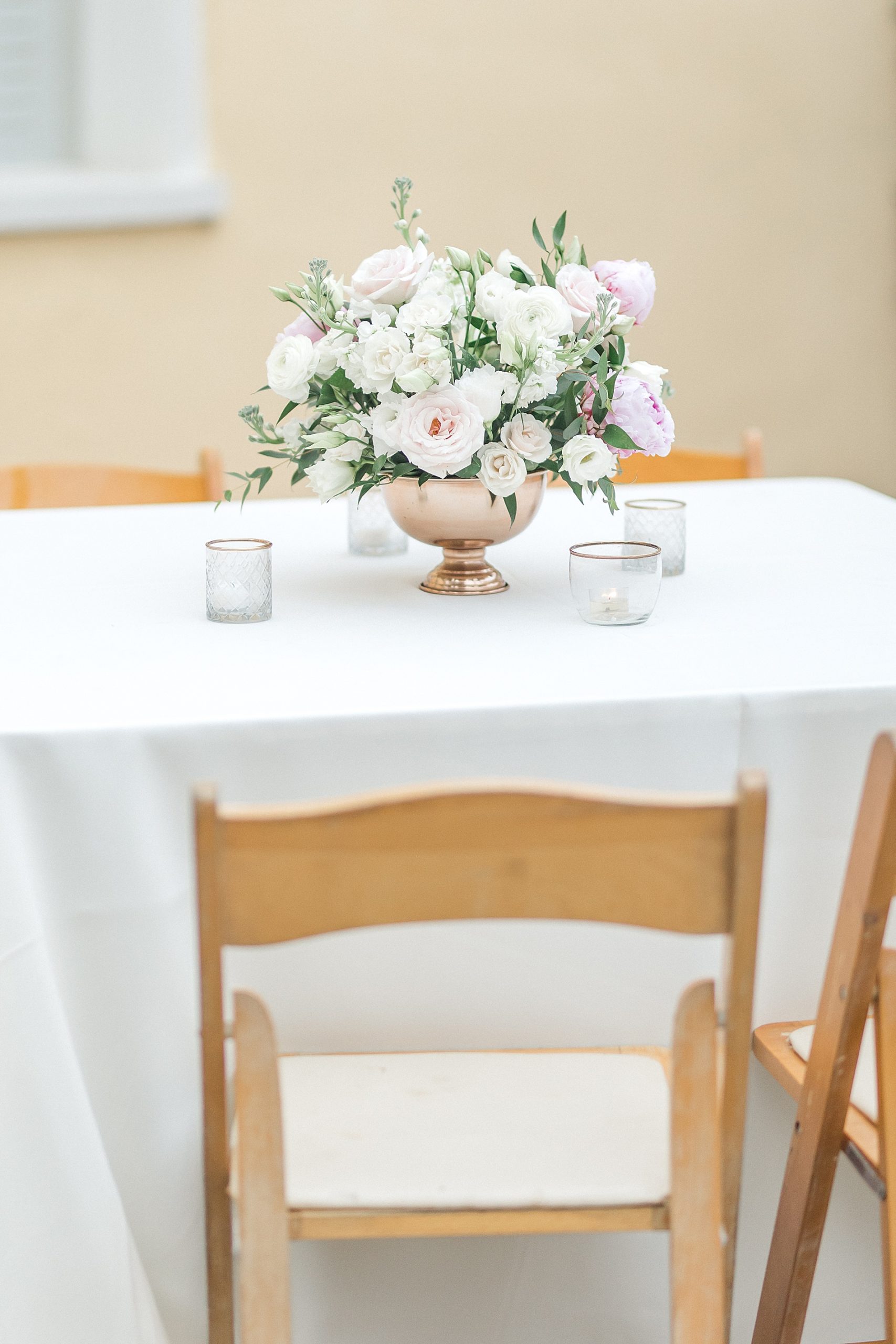 light-colored flower arrangements on center of tables