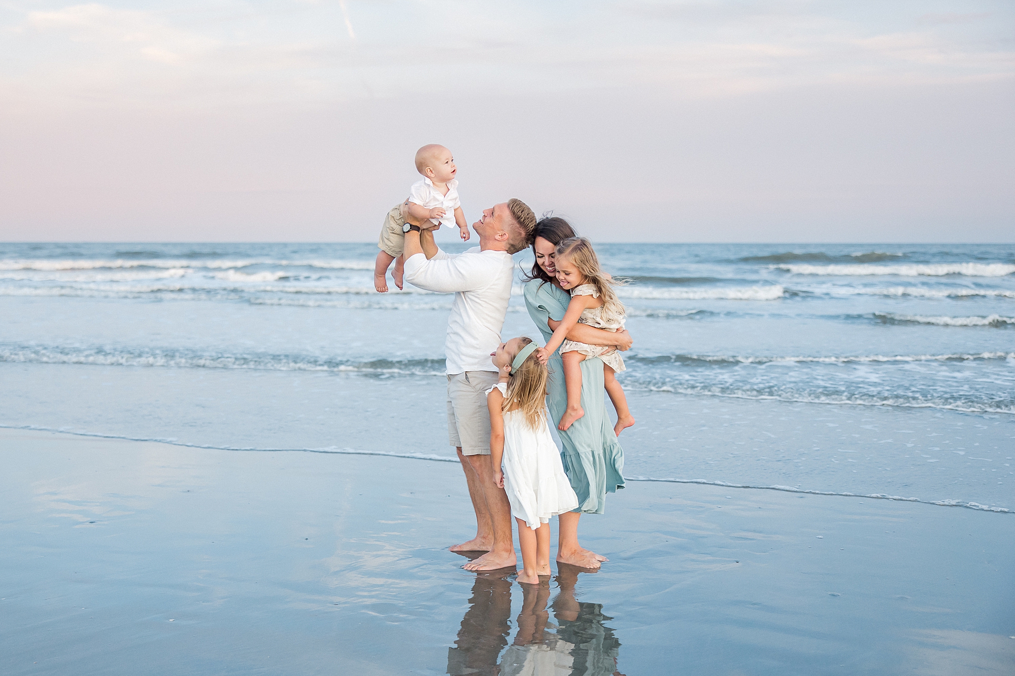 family stand in the water at Isle of Palms beach