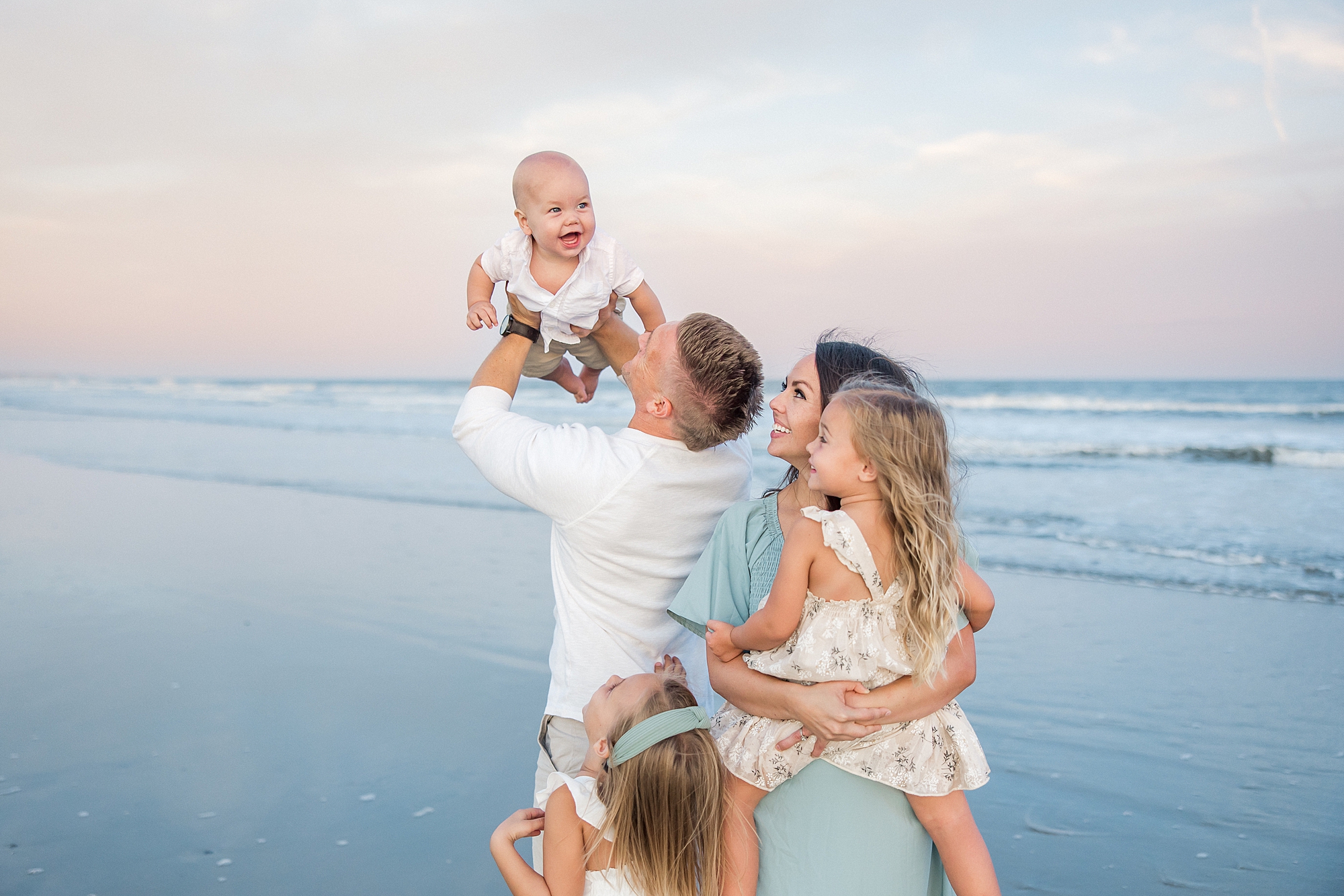 dad holds up son in the air as everyone looks up at him