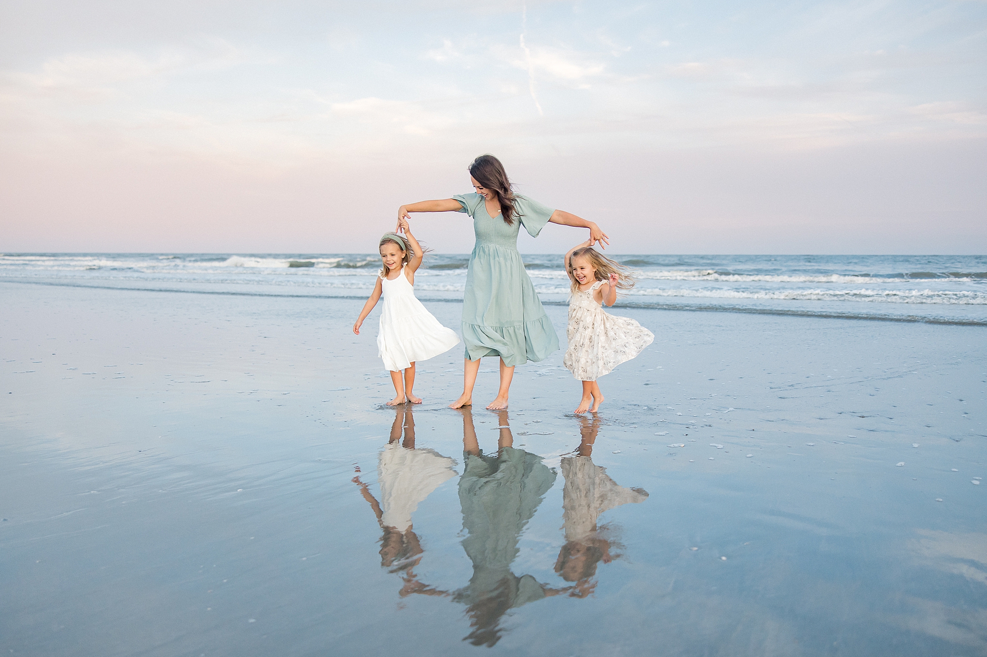 mom twirls her two daughters on SC beach