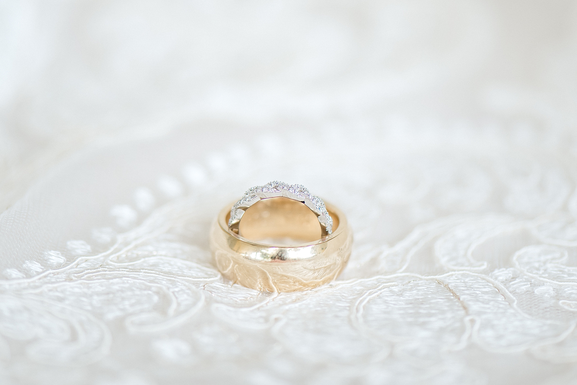 gold wedding rings on lace from wedding dress