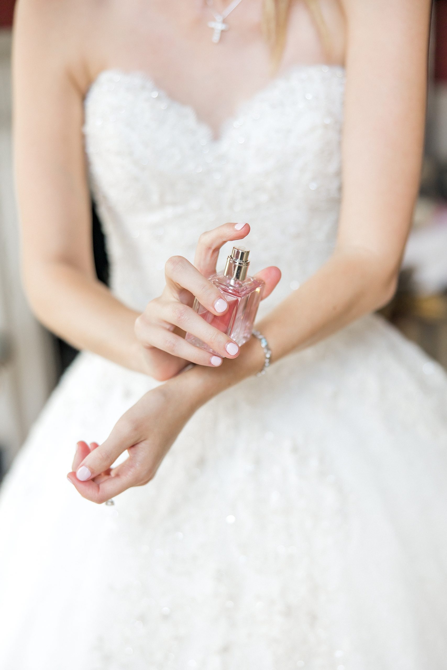 bride sprays perfume before Romantic Charleston Wedding at William Aiken House