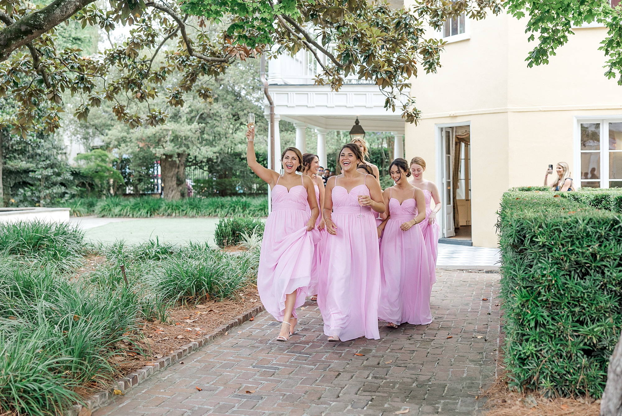 bridesmaids in pink dresses walk in reception