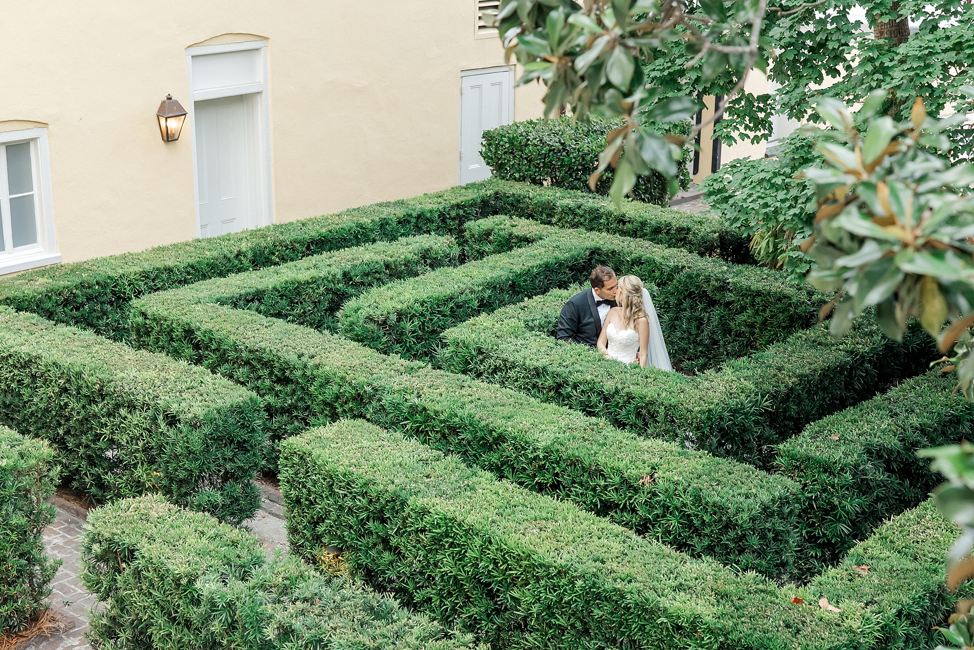 bride and groom in center of garden maze at Romantic Charleston Wedding at William Aiken House