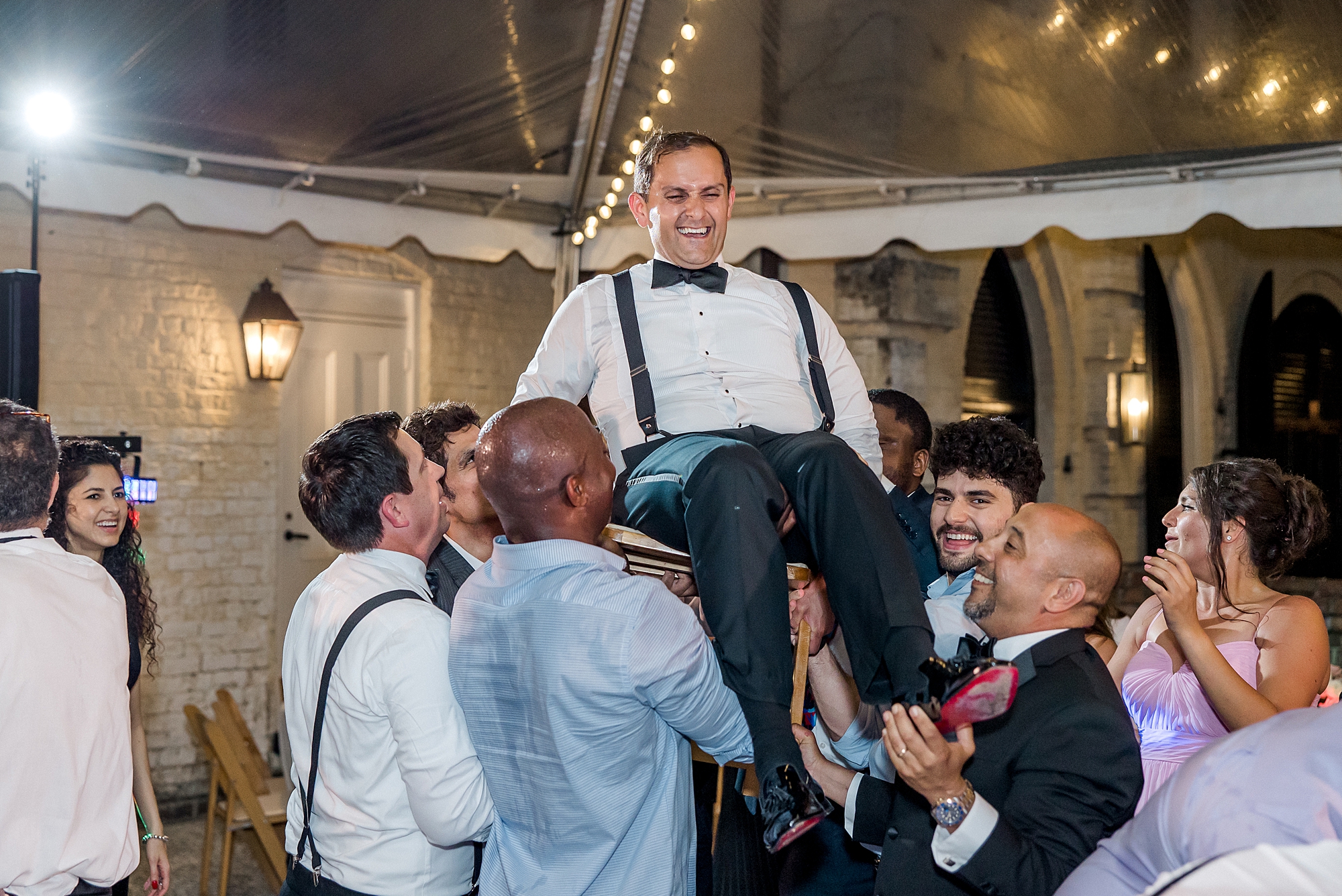 groom on chair lifted by groomsmen