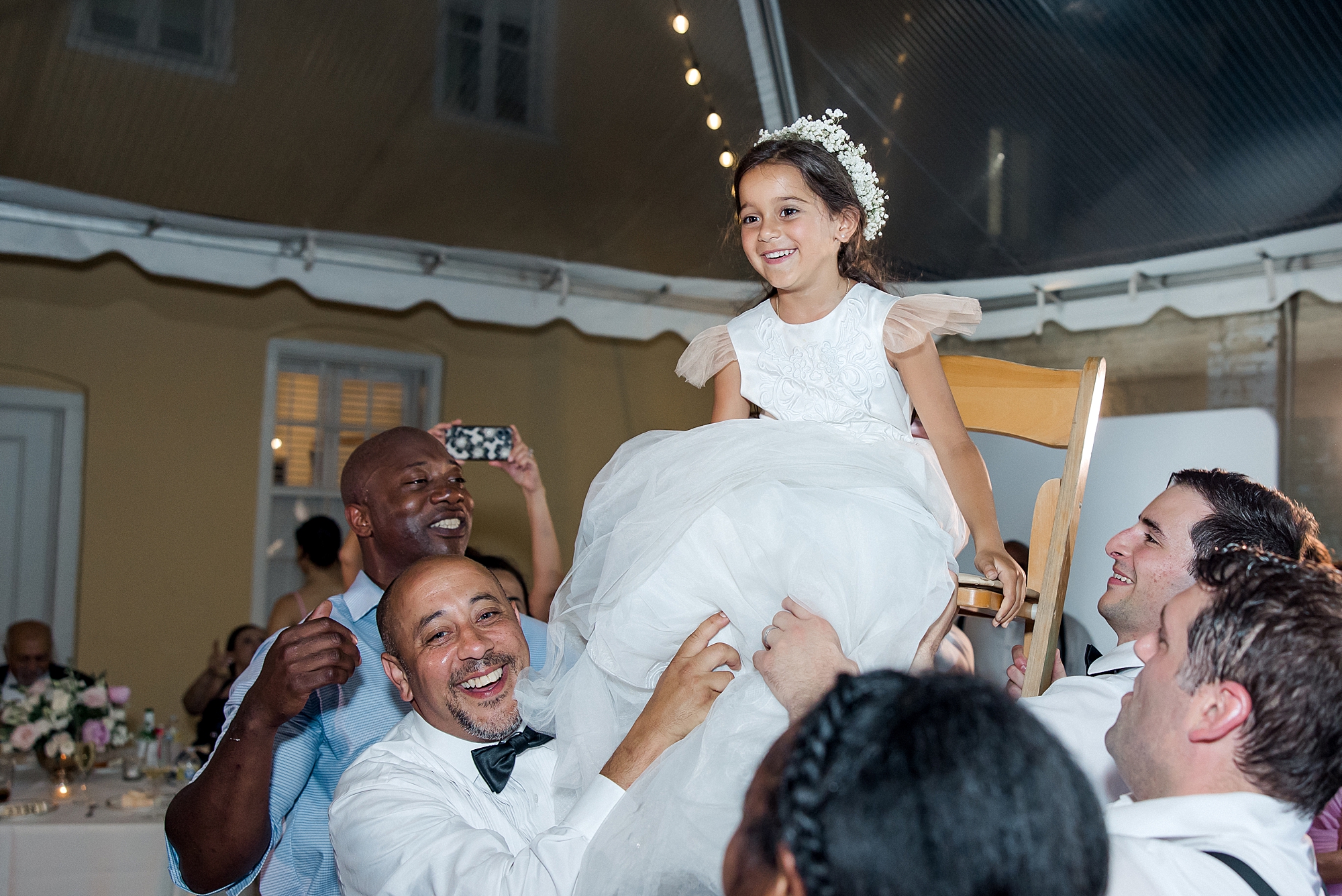 flower girl lifted into air on chair during Charleston Wedding at William Aiken House
