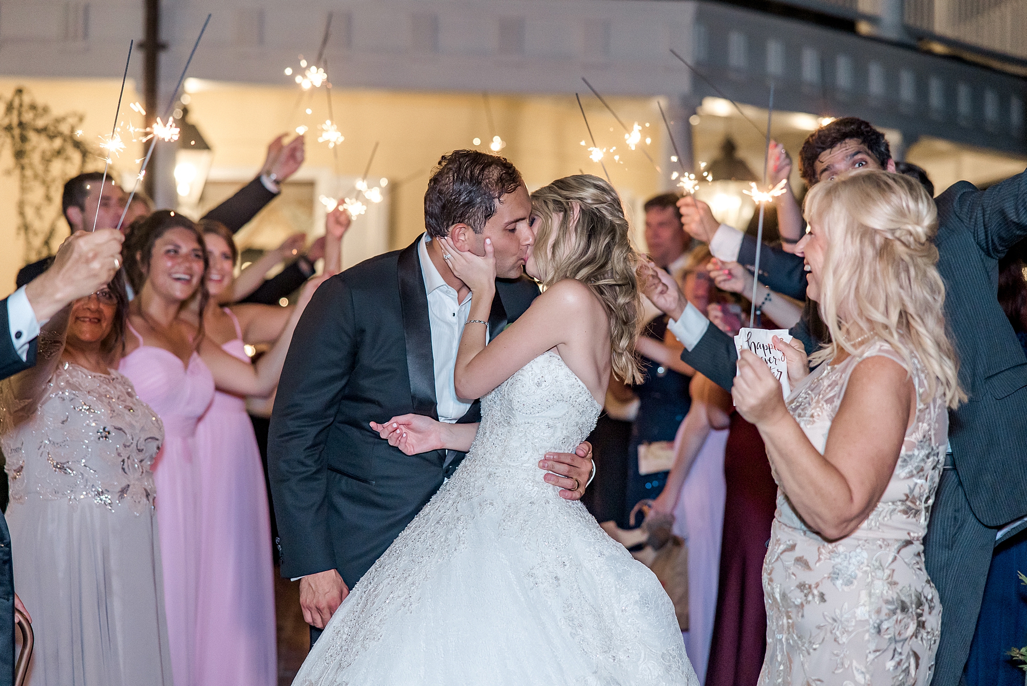 newlyweds kiss as they exit wedding reception