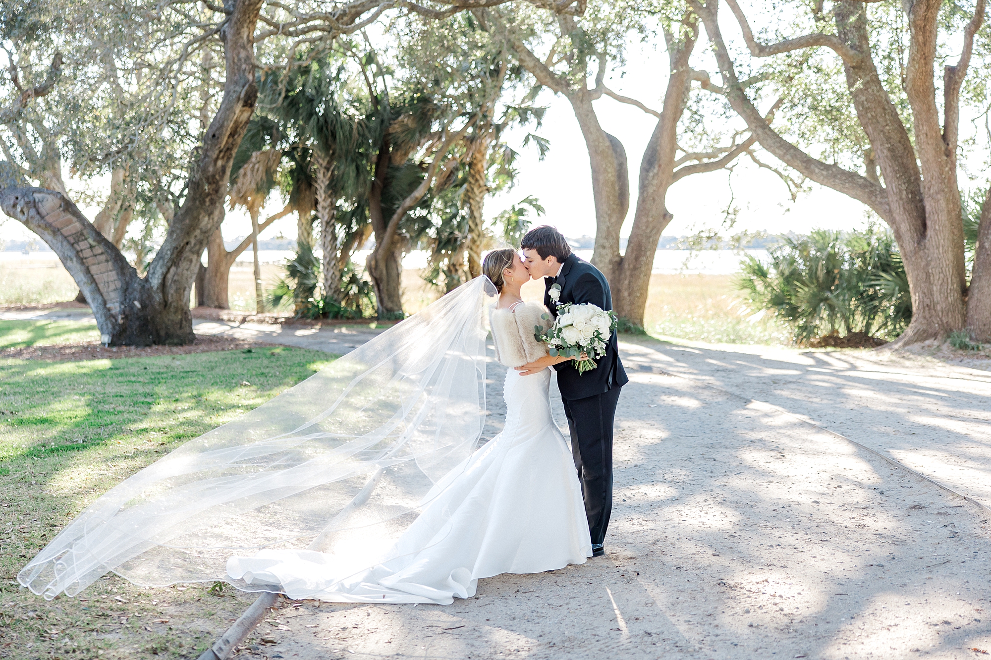 couple kiss before winter wedding at Lowndes Grove