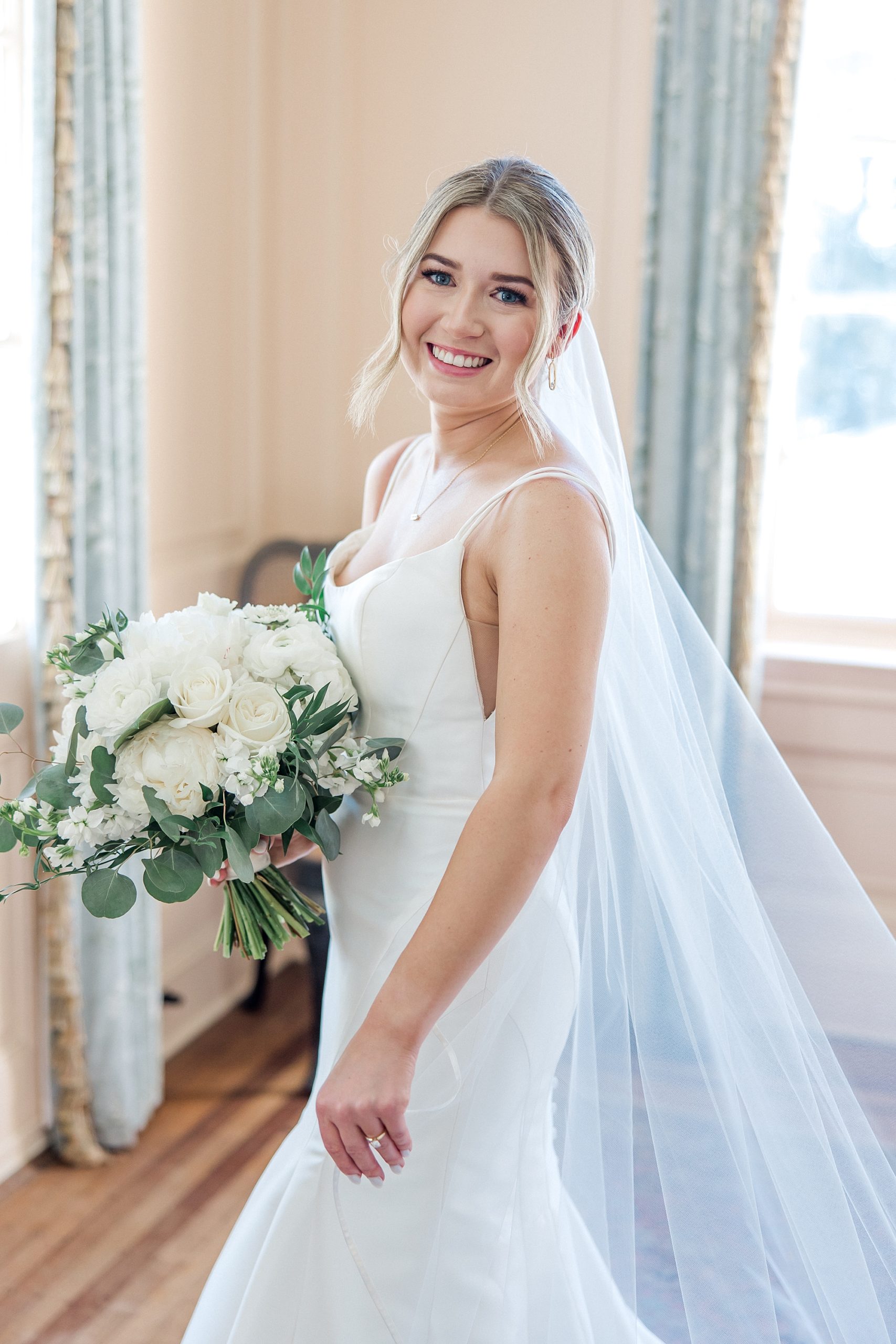 bride in wedding dress holding white and green wedding bouquet