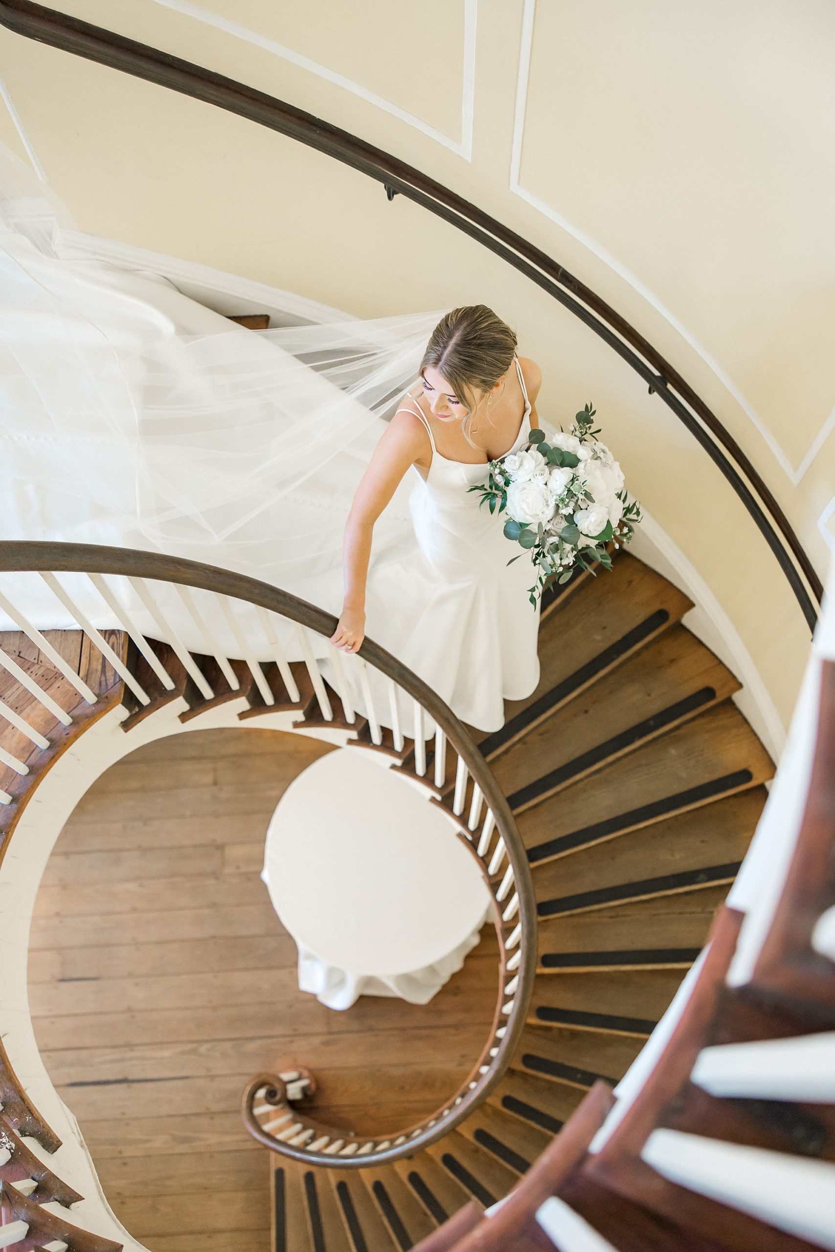 bride goes down spiral staircase at Lowndes Grove