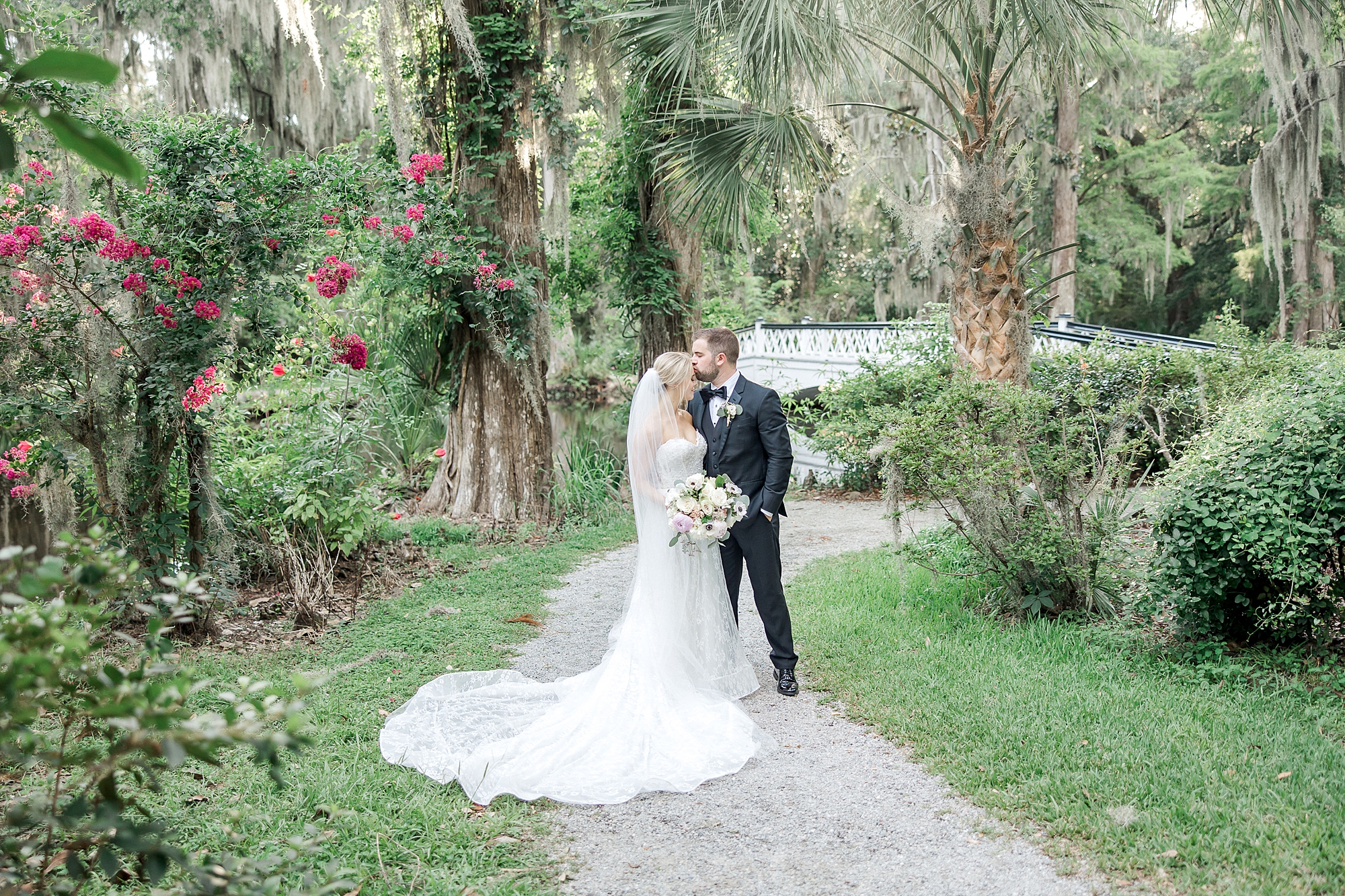 newlyweds kiss on the grounds of Magnolia Plantation and Gardens